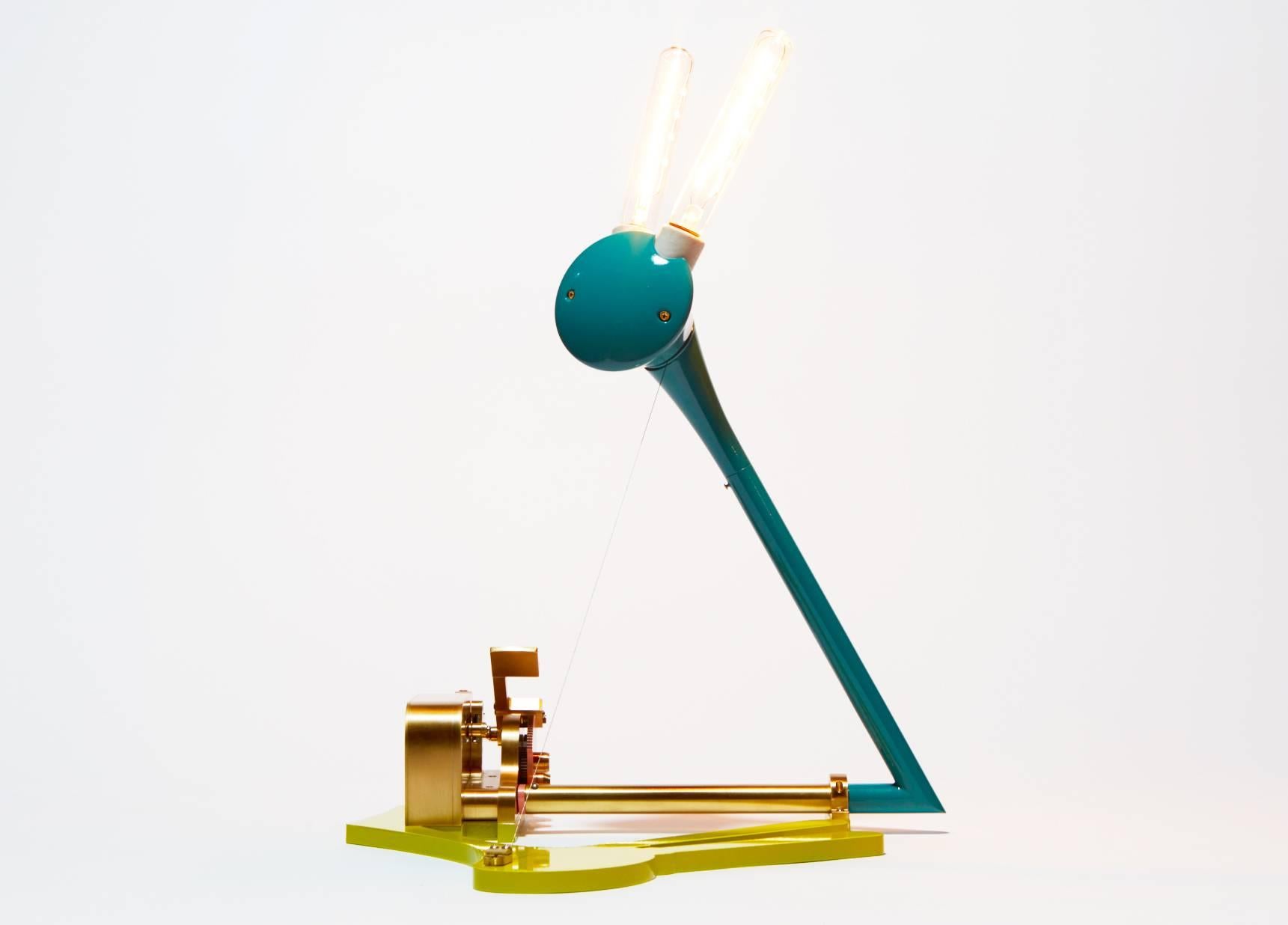 Every component of this contemporary light sculpture is handmade. A custom mechanical switch rotates the bulb assembly 180 degrees to bring this intricate assembly to life. In solid polished brass and lacquer in four color variations, and including