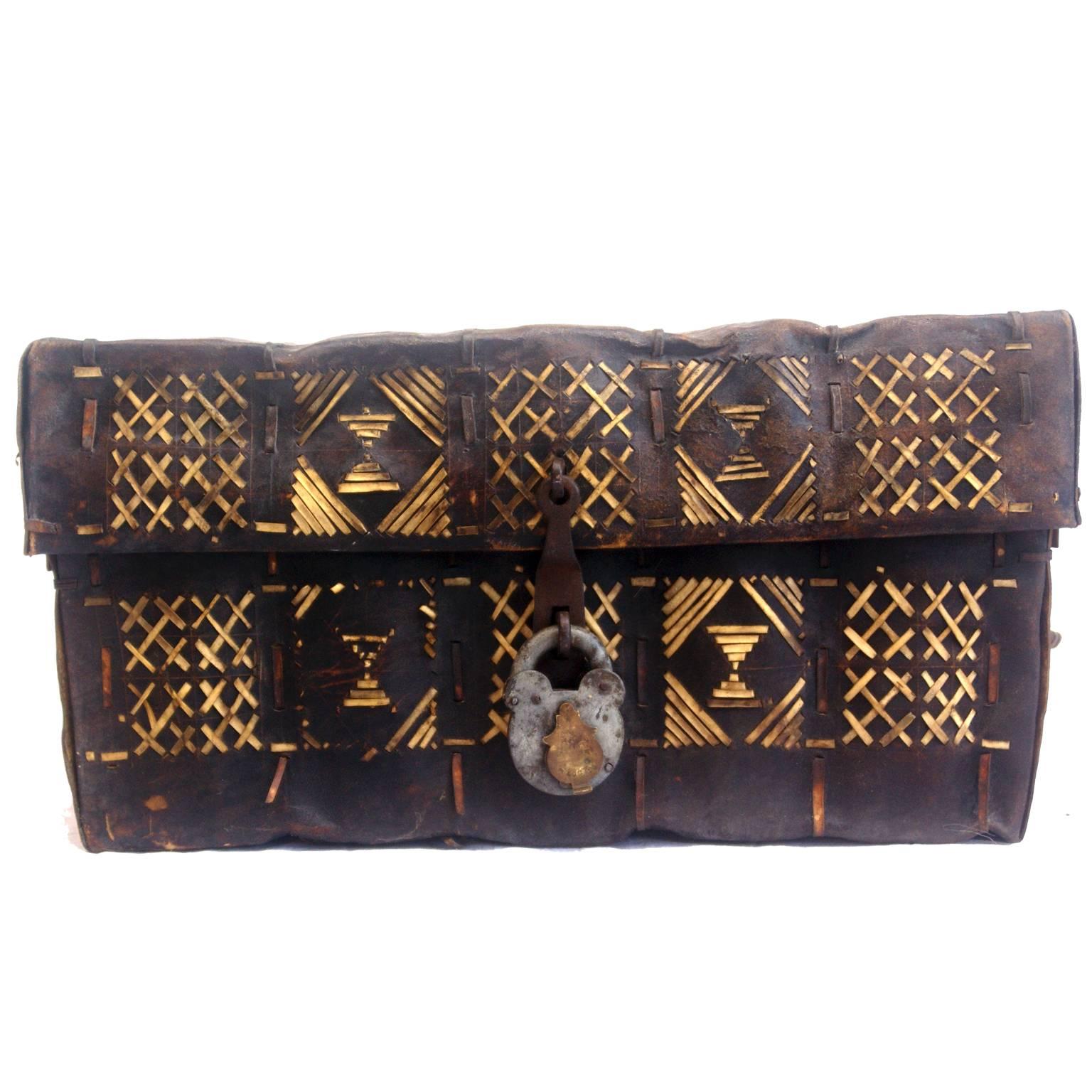 African rawhide deeds box. Extremely heavy-duty Leather box made by folding and then stitching hide with light coloured rawhide stripes in traditional geometric patterns.
The box is closed by means of a very heavy-duty hasp and contemporary padlock