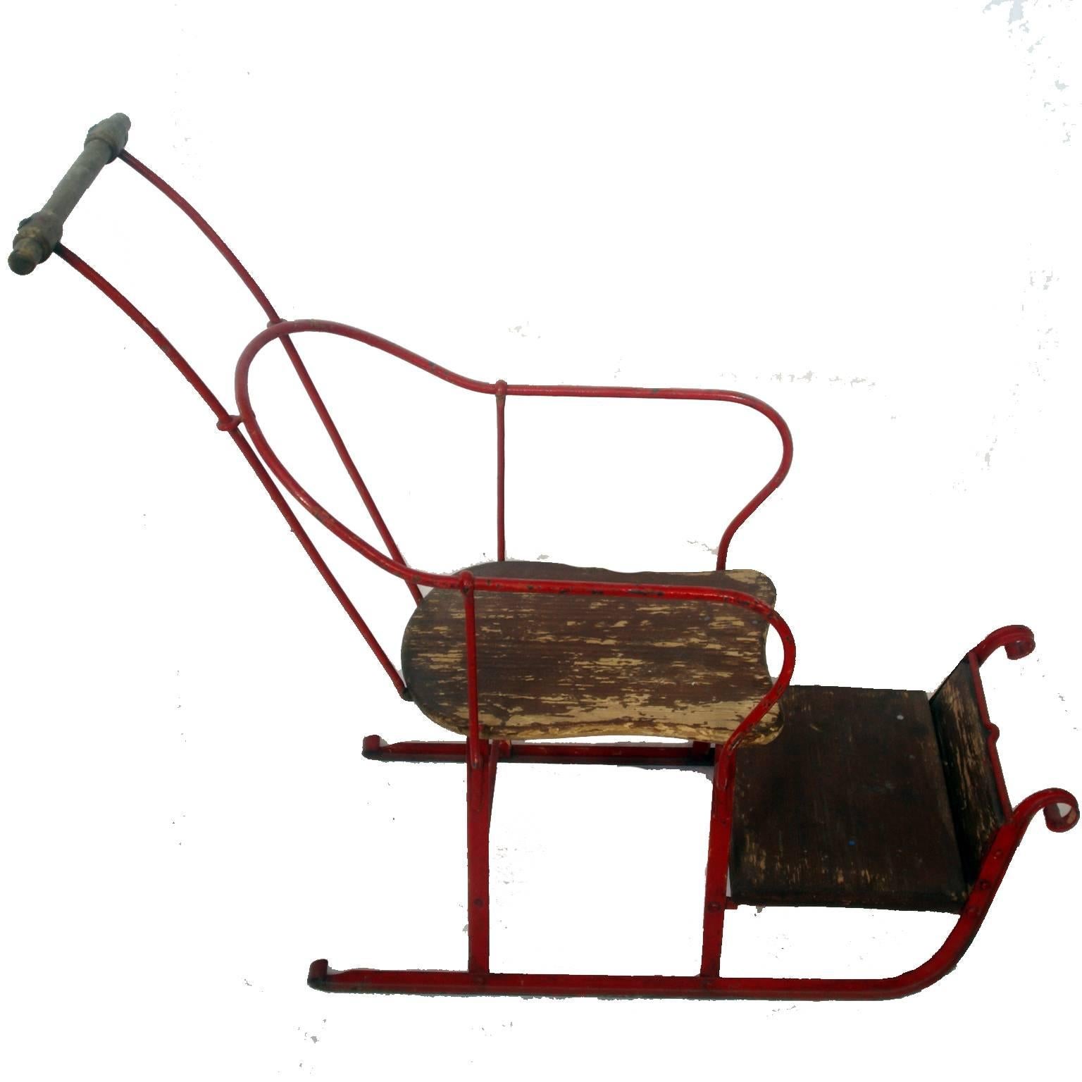 Early 20th century east European sleigh.
Blacksmith made push sleigh. Not a toy but used for pushing a baby or toddler on snow and when skating on the river. Original red paint and wooden seat. The piece is in exactly as found condition with no