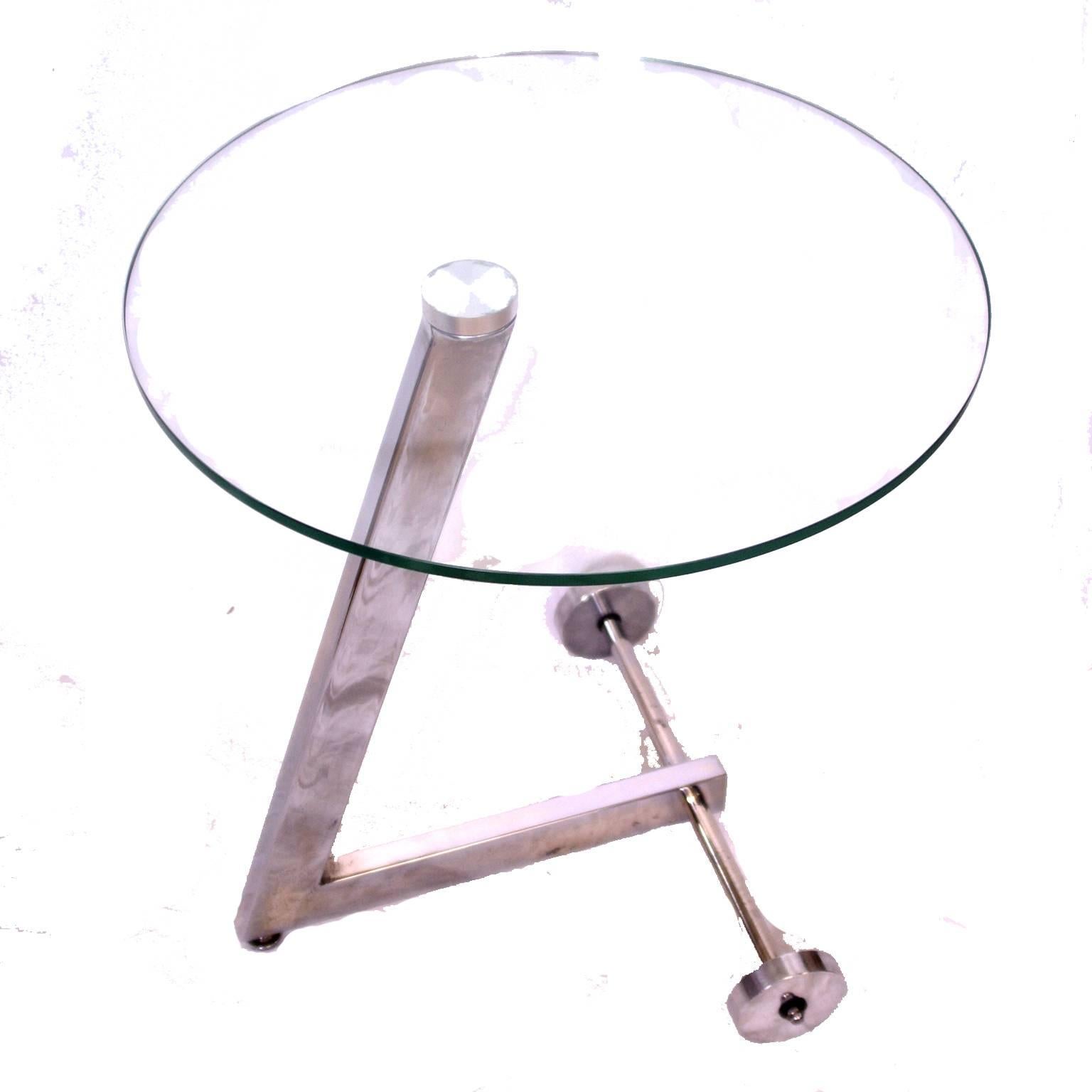 Round, 1960s glass and chrome wheeled side table. 
Glass side table on chromed steel stand with two solid aluminium wheels.
Striking and unusual table in good original condition. Unrestored, the item has a gentle patina with some loss of the