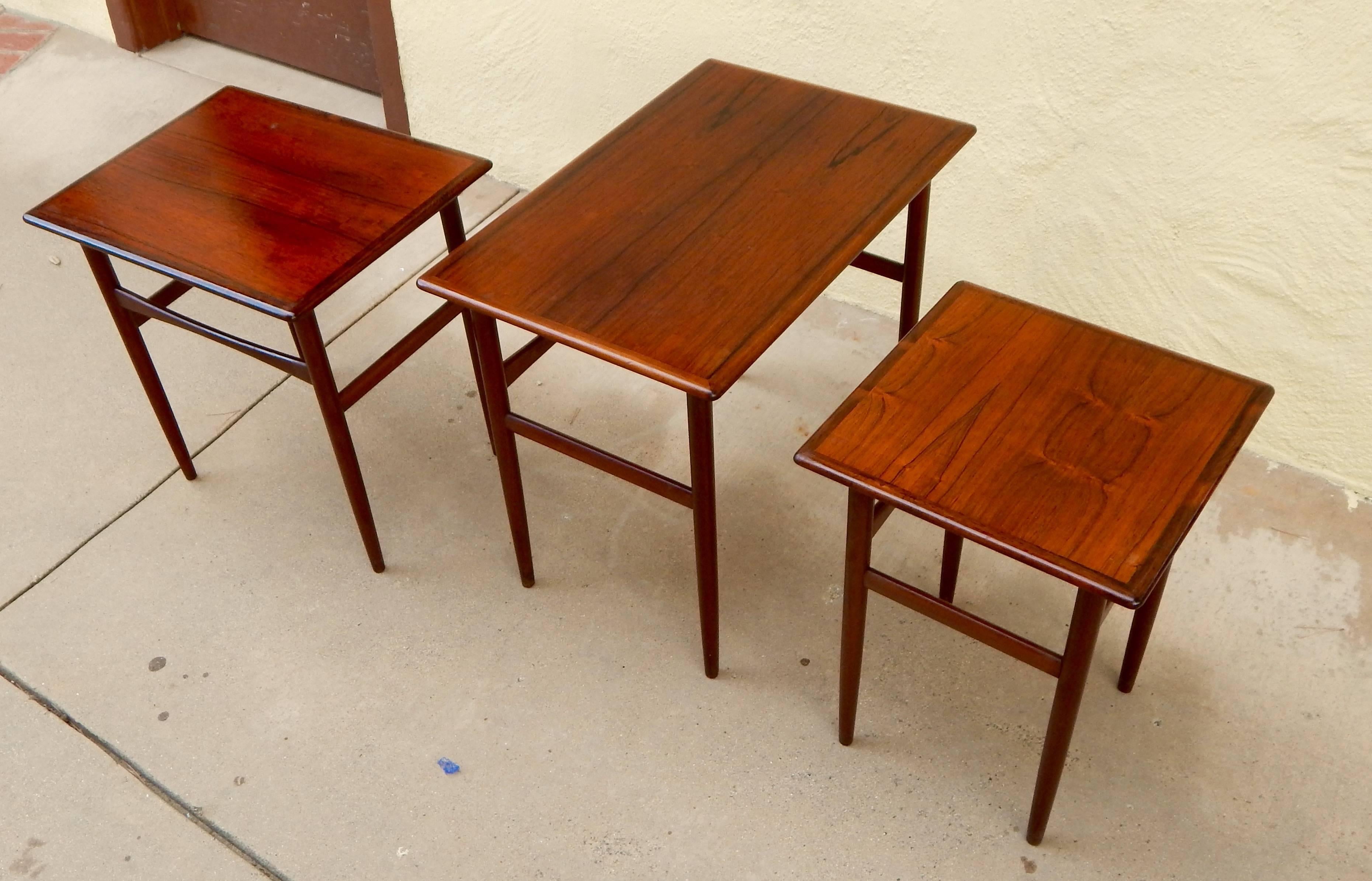 Set of three Swedish Mid-Century Modern rosewood nesting tables, circa 1950. Please see the detail photographs to see the underside hinges which house the smaller table. These are in excellent antique condition in original finish. Please contact us