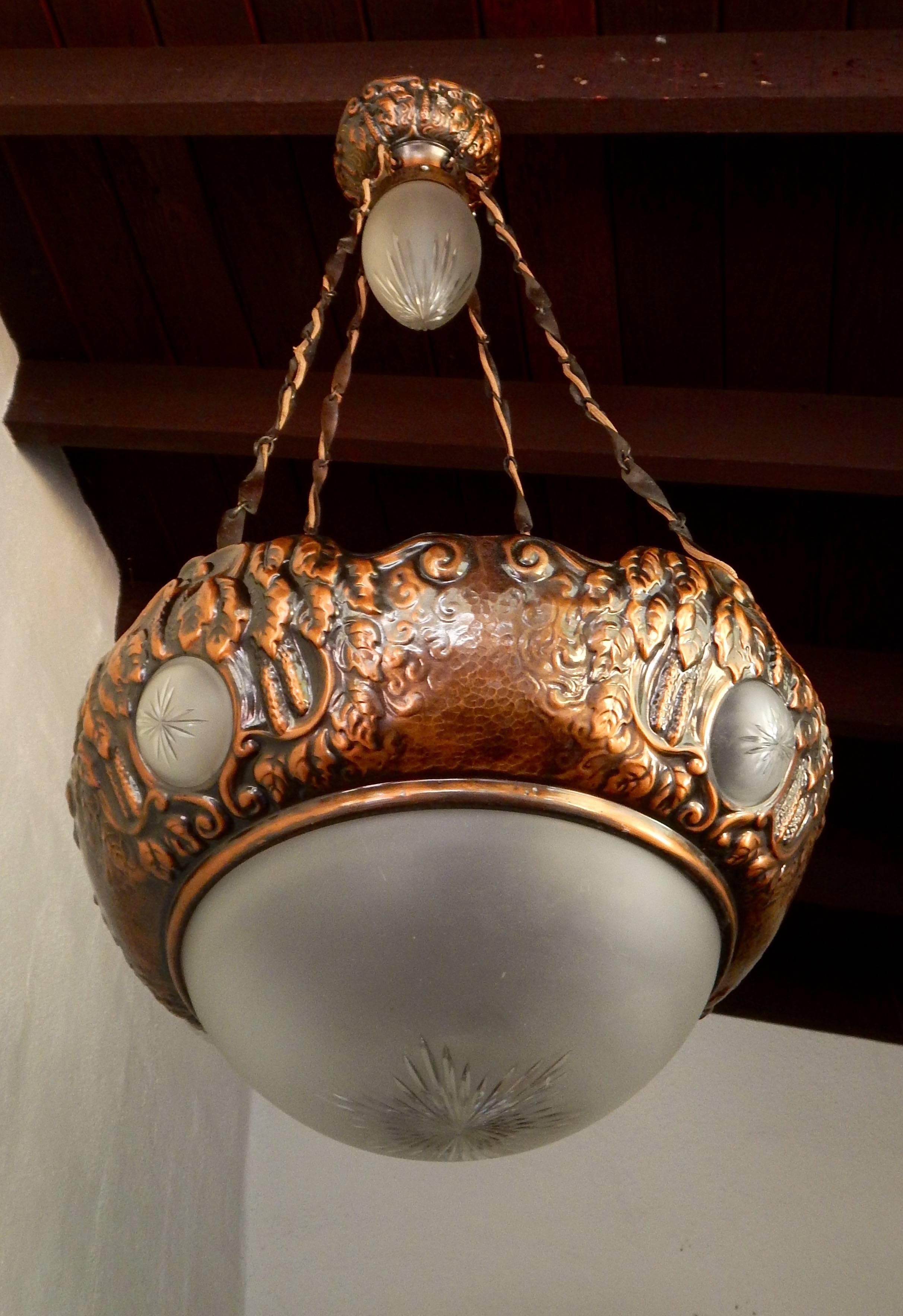 Swedish Victorian hand-hammered copper and glass hanging fixture with floral motifs, circa 1900. All glass is original to fixture and is in excellent condition with some minor scratches. The fixture can be shortened significantly. Price includes