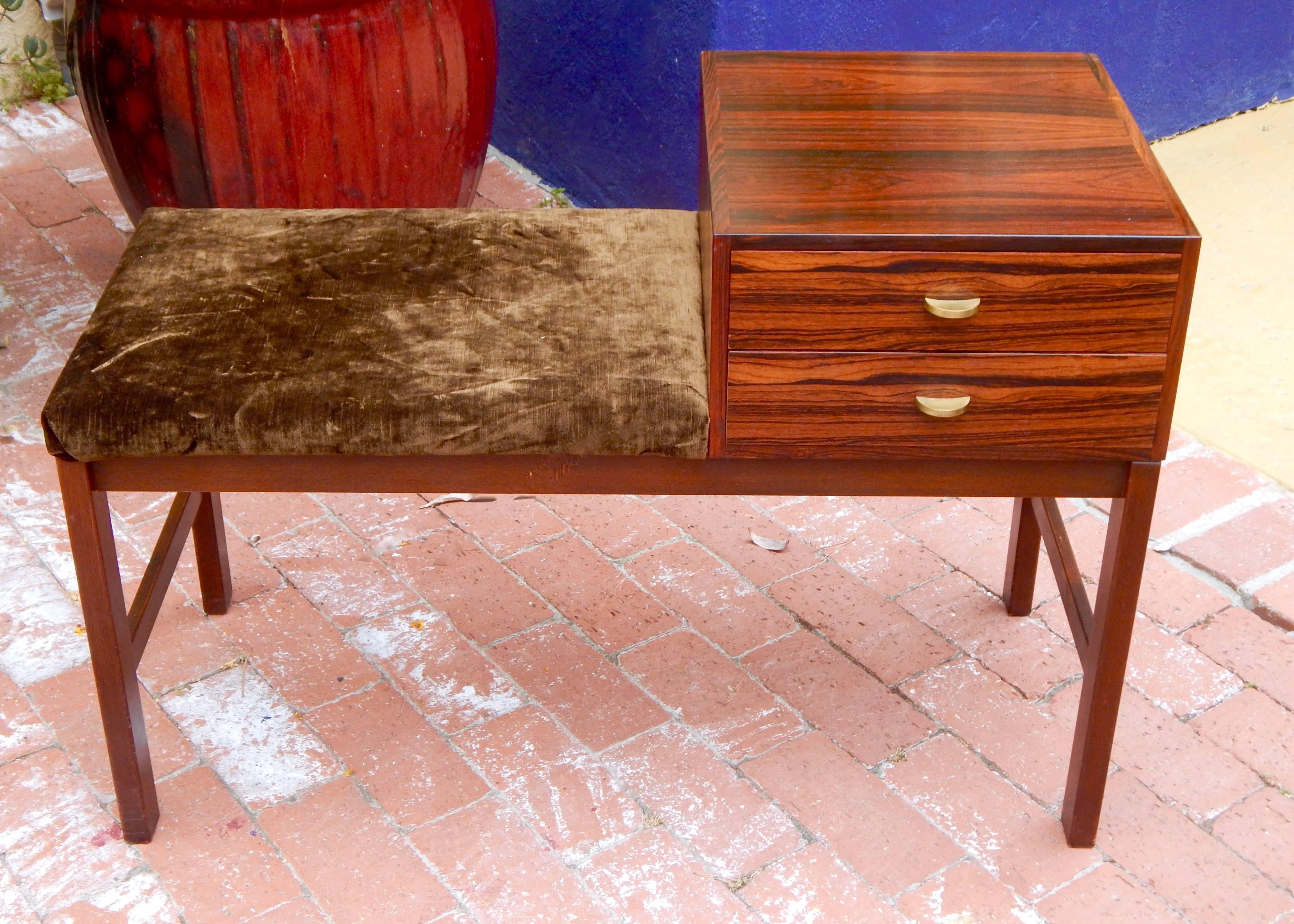 Swedish Mid-Century Modern rosewood bench chest or side table. Rendered in highly figured bookmatched rosewood. With patinated metal pulls. Two drawers. I have photographed this piece with temporary fabric. It's a cinch to recover in a fabric of