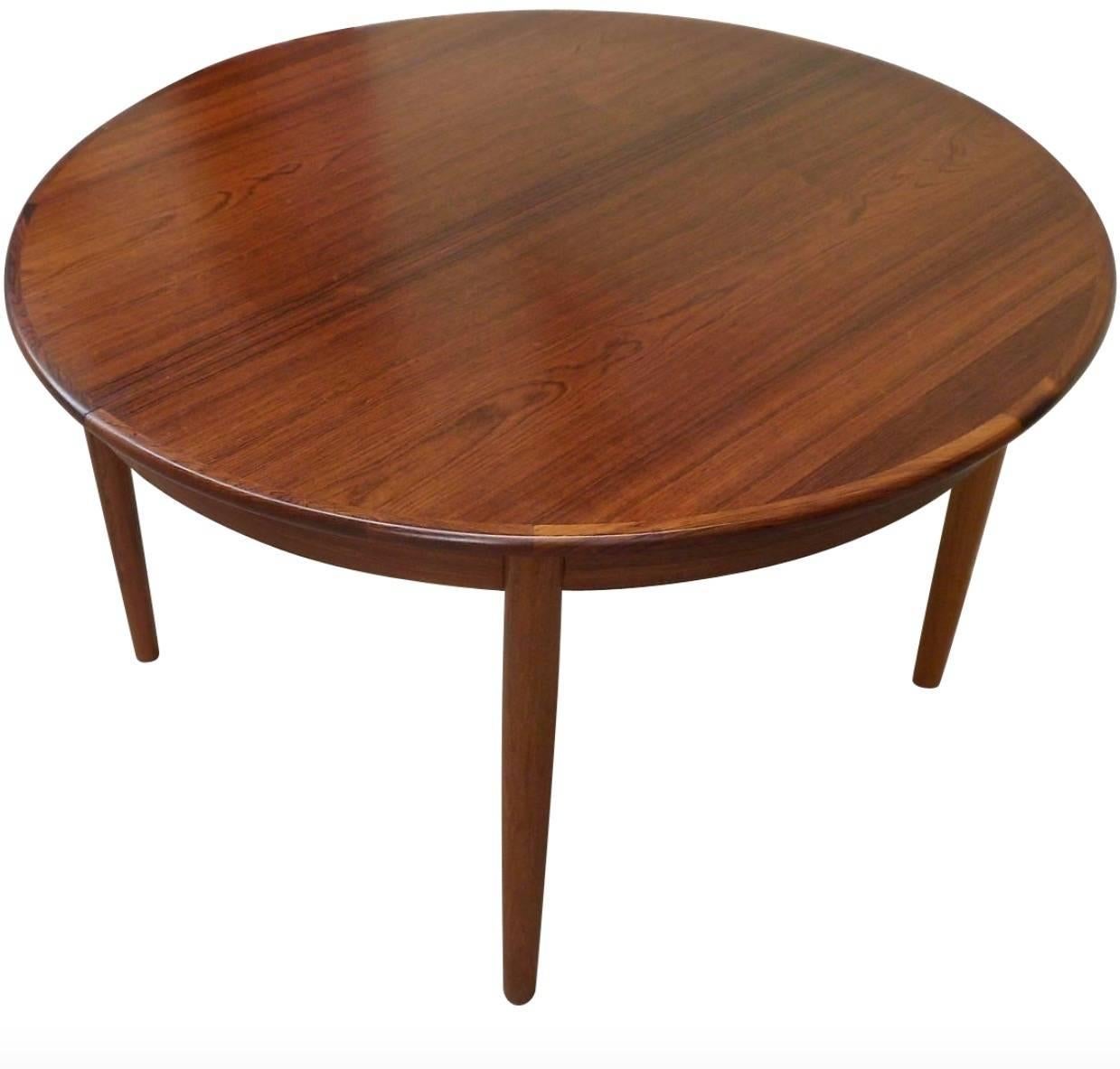 Danish Mid-Century Modern extendable rosewood dining table. Table sits round at 46" and had two matching 19.5" rosewood leaves. With leaves the table can seat eight diners comfortably-at 85" extended. Table and leaves have just been