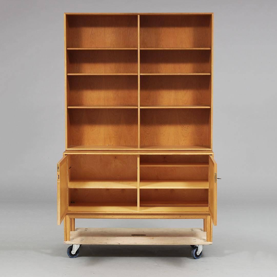 Swedish Mid-Century Modern book case and storage cabinet. In bleached ashwood with grass cloth inset panels. In excellent original condition. Shelves are removable and adjustable. See photos for greater details. Made at Alf Svensson, Bjasta, Sweden,