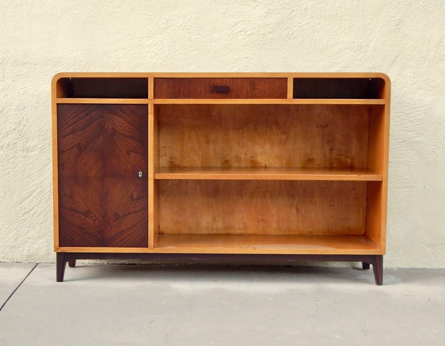 Swedish, 1940s moderne bookcase or sideboard rendered in elmwood. With highly figured bookmatched elmwood doors. One adjustable and removable shelf. Interior also with shelf. Restored by our woodworkers to its original luster.