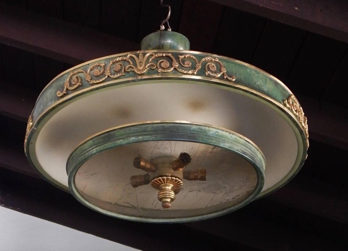 Swedish Art Deco era Gustavian inspired 'plafond' (Swedish term for flat disk glass) hanging fixture circa 1930. The bands are composed of metal with painted finish. Decorations are cast gilded metal. With three standard base up lights and five