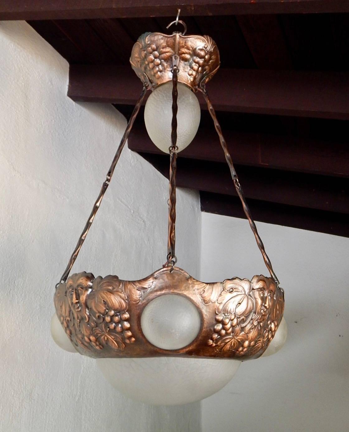 Swedish arts and crafts hanging fixture composed of hammered copper and Frosted glass. All shades are original. There are a total of five electrical sockets on this fixture, all with standard bases. Price includes complete rewiring. Sweden 1910