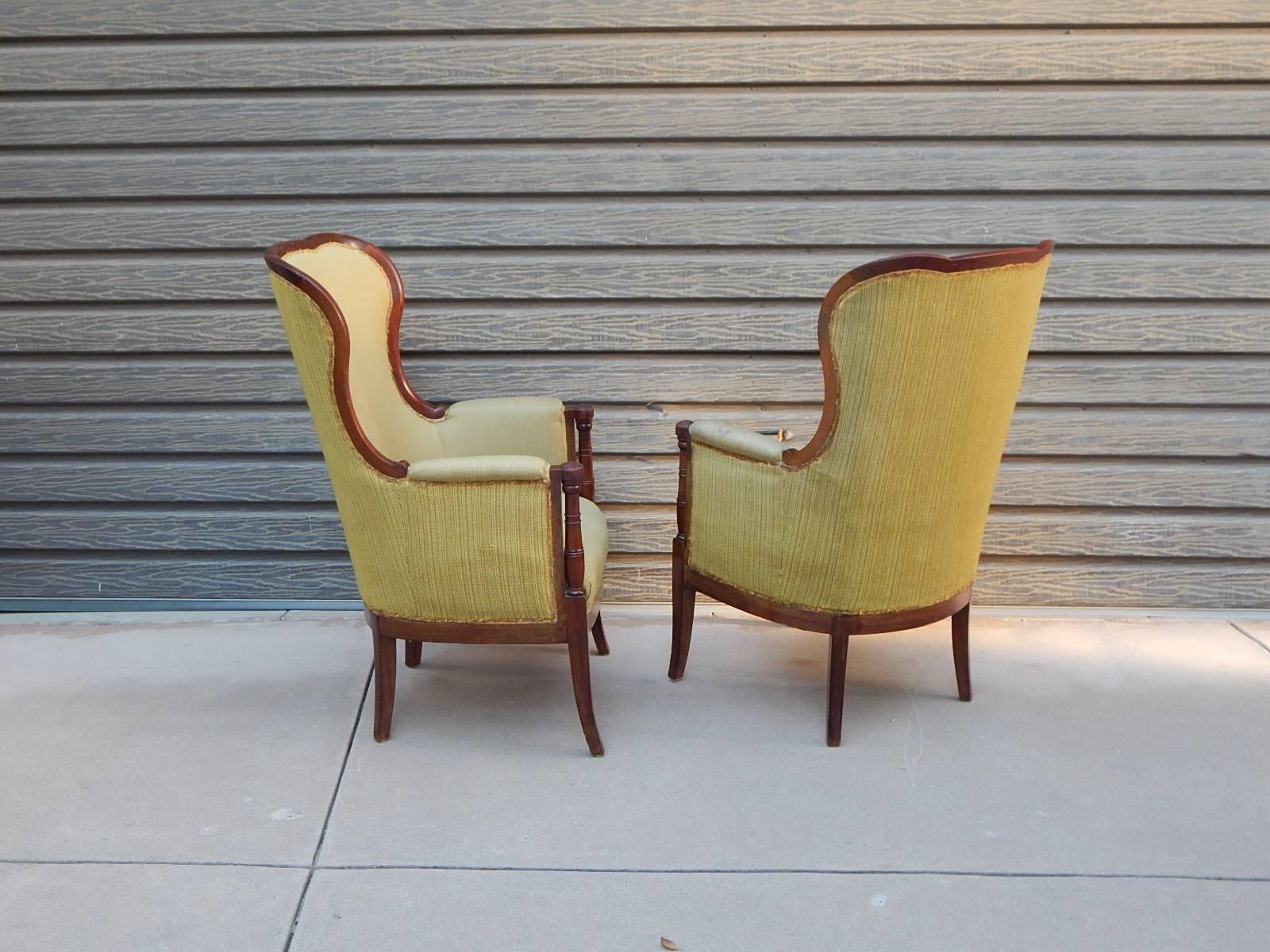 Pair of Swedish exposed framed winged back chairs in mahogany. With column detail at front leg crest. In original condition.  Sold as acquired. Circa 1920.