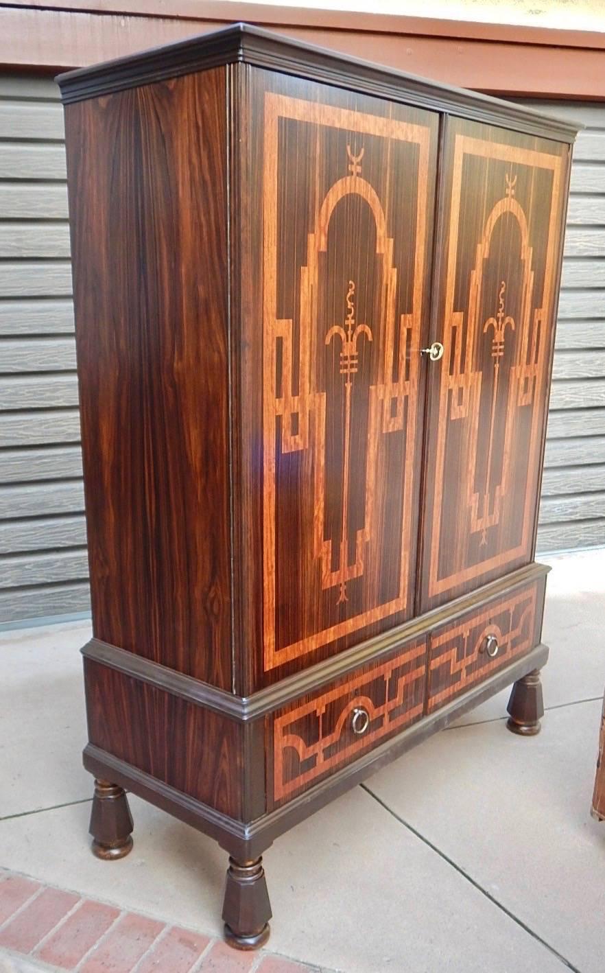 A very rare Swedish Art Deco storage cabinet rendered in zebra and rosewood. With geometric inlay. There are two original shelves which are removable and adjustable-and not shown in the photos. There are two storage drawers at the bottom of the
