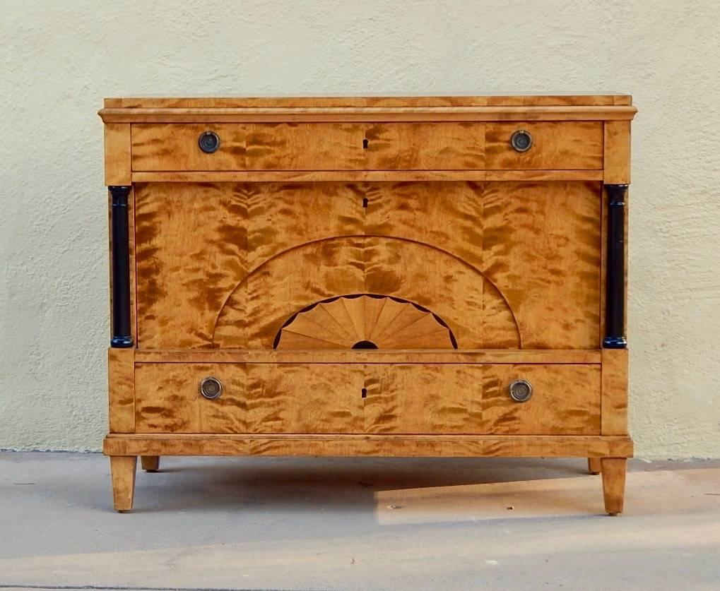 Swedish Biedermeier revival bar cabinet or chest of drawers rendered in highly figured golden flame birch wood. Sunburst inlay in birch and ebony. Two drawers with original neoclassical pulls. The inner cabinet is perfectly sized to accommodate wine