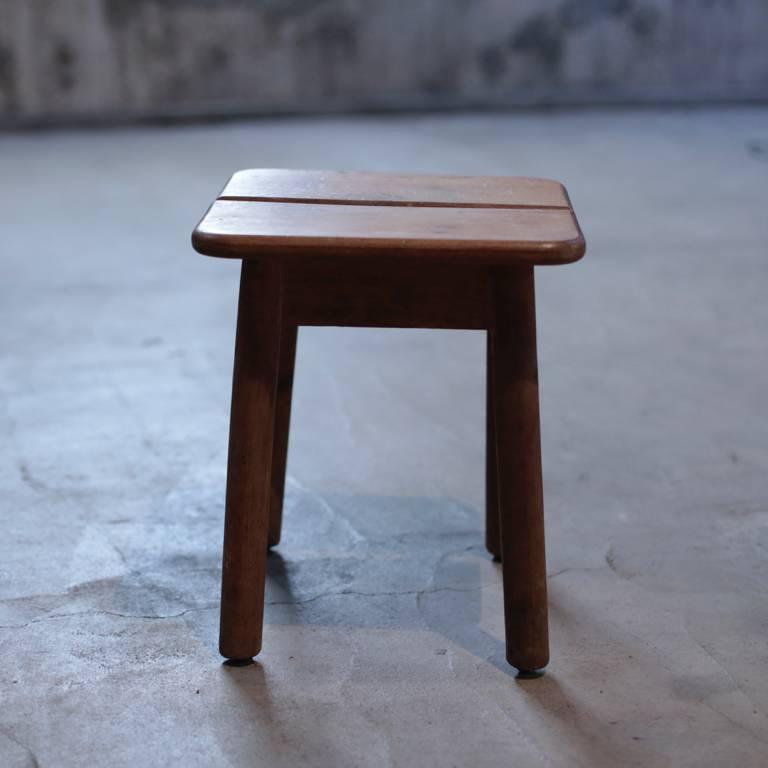 Vintage stool with a seating surface divided into two.