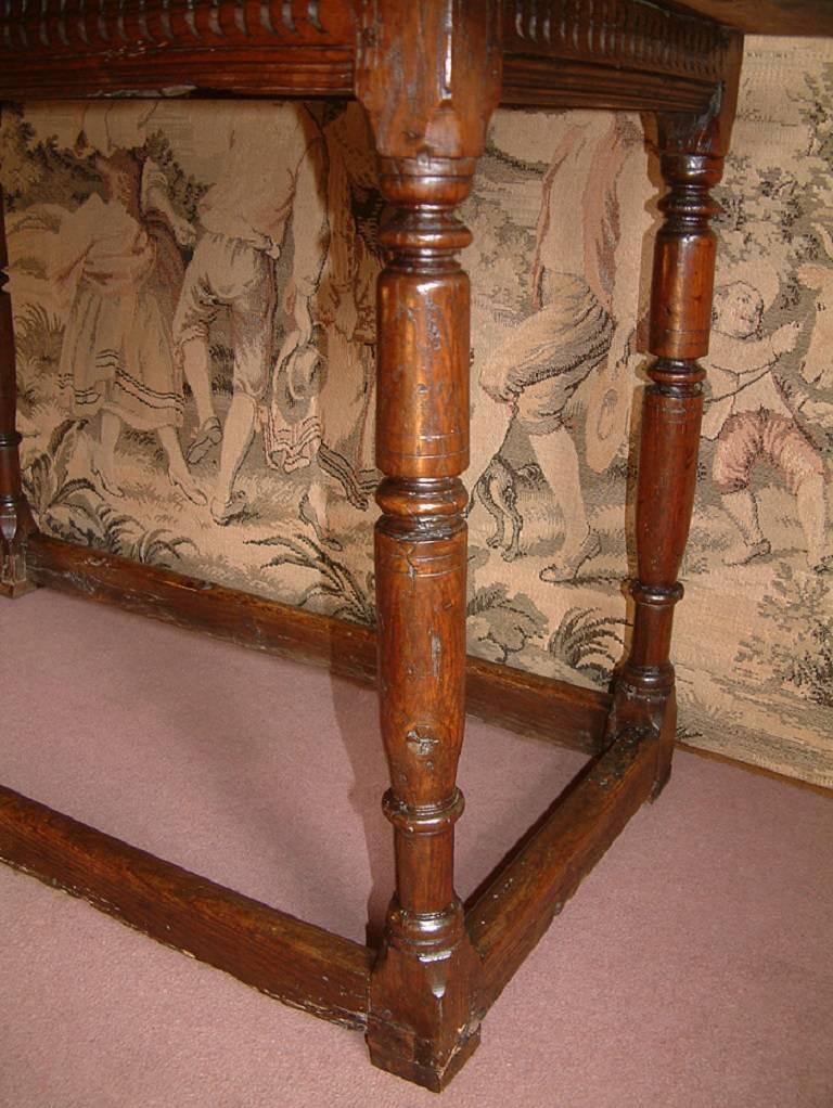 A 17th century refectory supper table dating from circa 1680. The twin plank top above a carved frieze resting on ring turned legs joined by base stretchers. 1 cm blocks added to the base of each leg due to deterioration of timber due to standing on