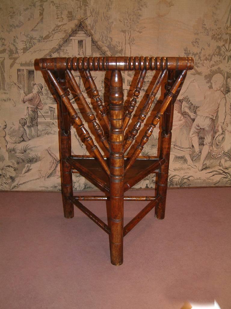 An oak "Turners" chair dating from circa 1650. The seat of triangular form and with various profusely turned spindles and supports. These chairs, typical of the 17th century were constructed to demonstrate the skill of an individual