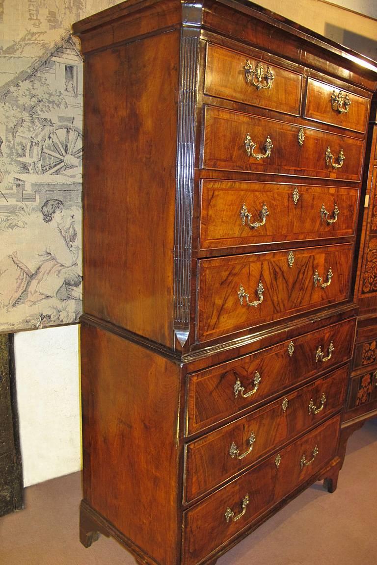 A George II period walnut chest on chest dating from circa 1760. The top with architectural concave cornice above two short and three long feather and crossbanded figured Walnut Oak lined drawers with Ormolu handles and escutcheons. The base with