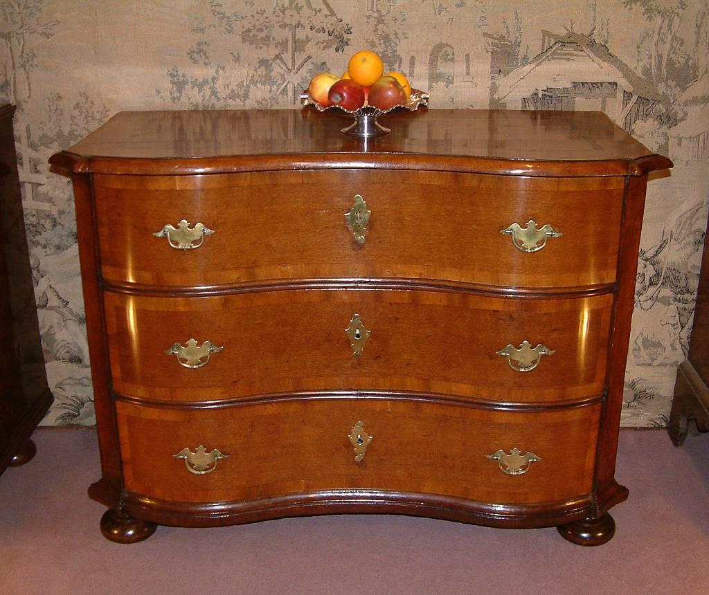 A late 18th century oak and walnut Northern Italian / Southern German serpentine fronted commode dating, circa 1780. The serpentine Oak top with walnut crossbanding and ebony, walnut and fruitwood marquetry inlay and ogee moulded edge above three