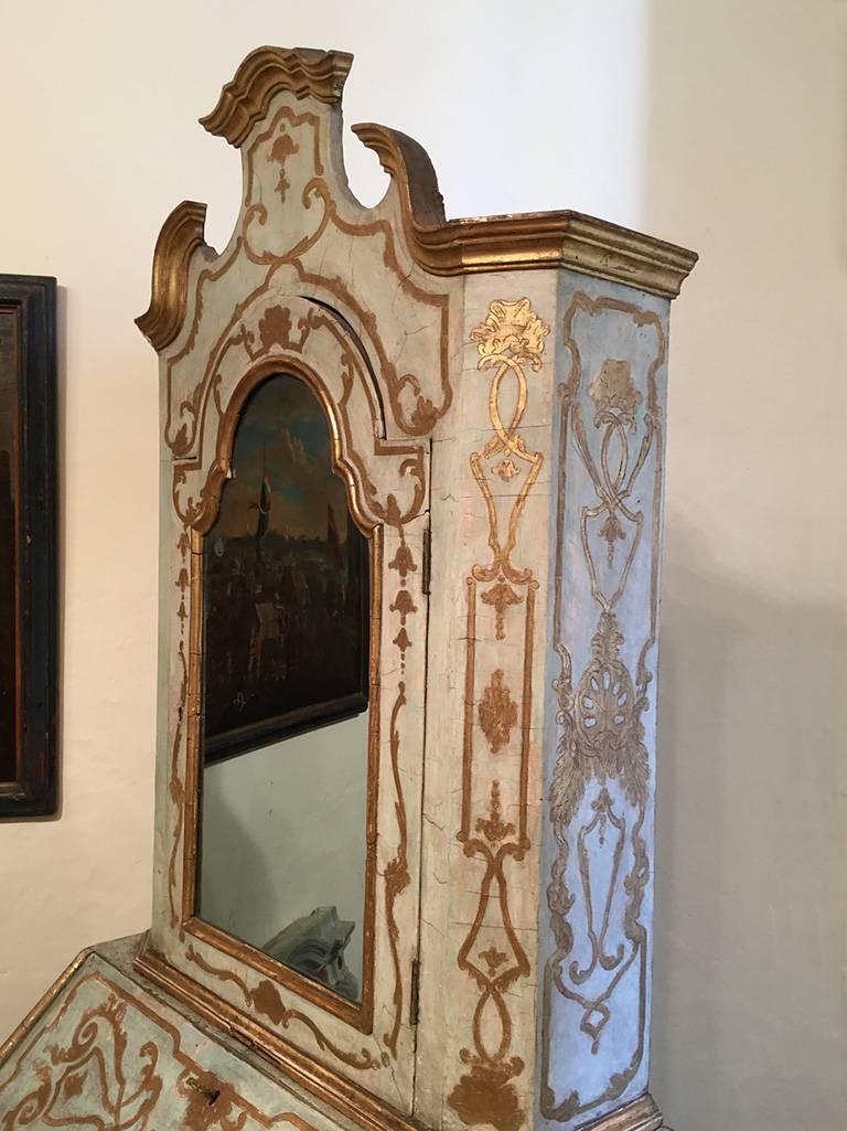 A superb extremely rare Italian early 18th century Venetian painted and parcel-gilt Bureau cabinet dating from circa 1730 and in original condition. The cabinet top with gilt broken arch cornice above a single mercury mirrored ( some deterioration