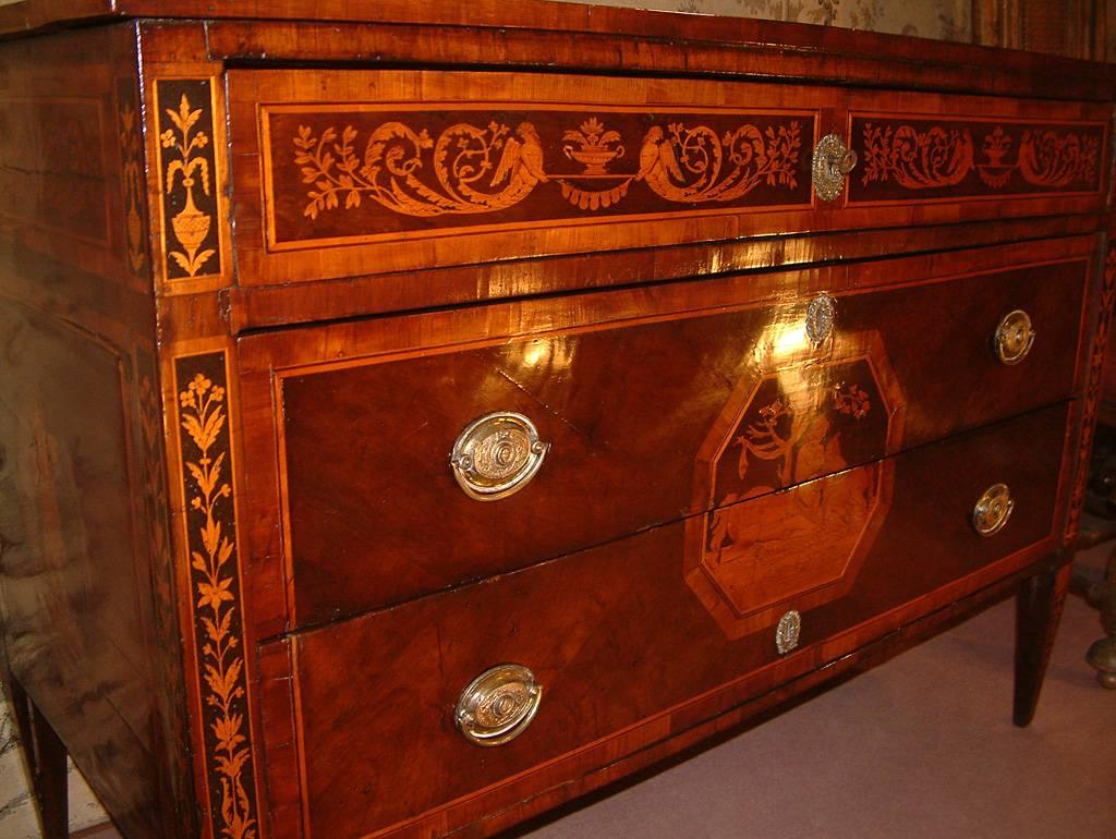 A fine neoclassical Italian Milanese walnut commode with marquetry inlays dating to circa 1770 and possibly from the workshop of Giuseppe Maggiolini. The rectangular top with satin wood stringing, fruitwood crossbanding and central musically themed