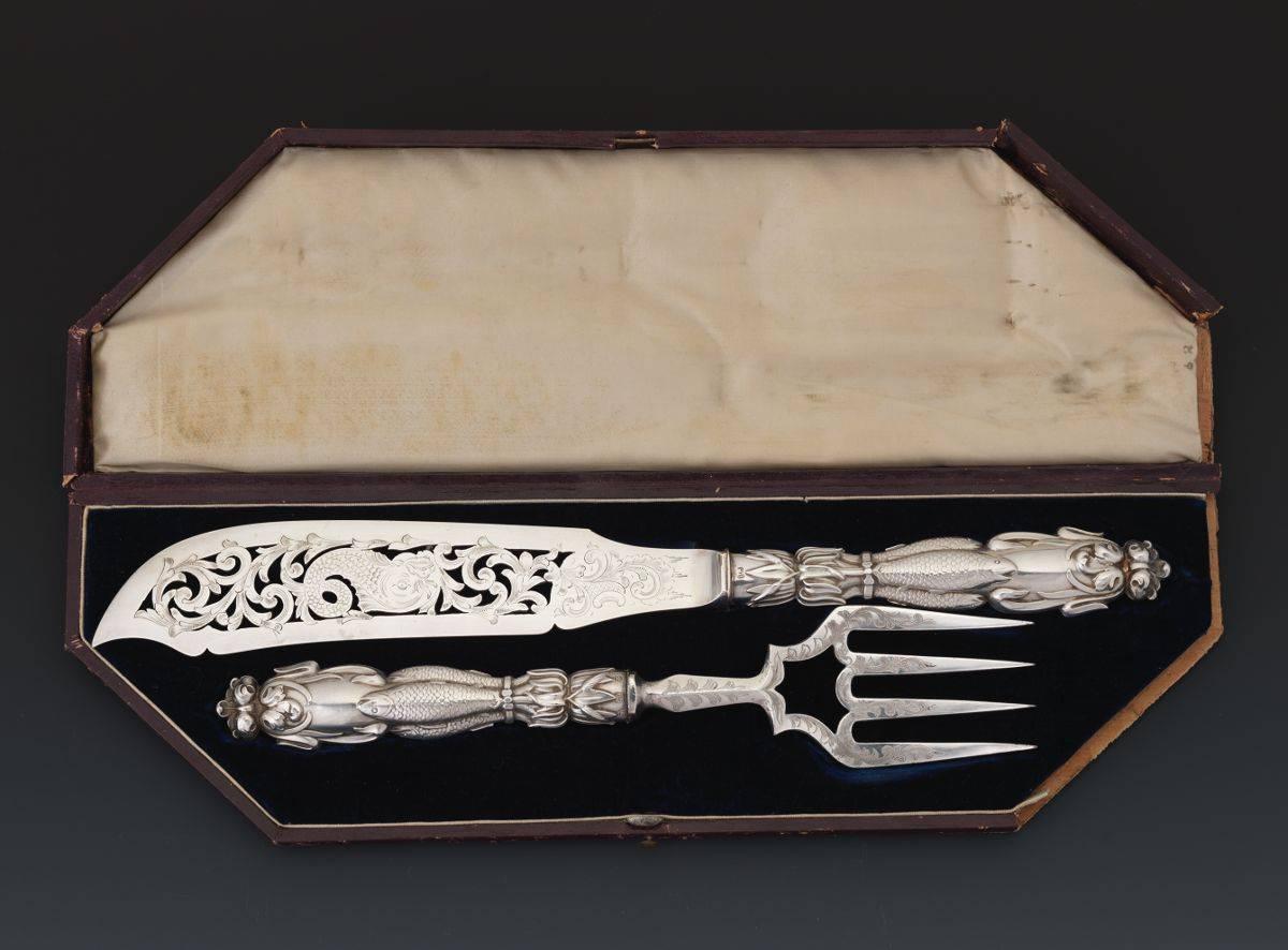 A Victorian English sterling silver fish serving set, by Atkin Brothers, Sheffield, circa 1838-1890

Sterling silver handles with fish and scroll designs in high relief, silver plate reticulated blades with engraved motifs; handles fully