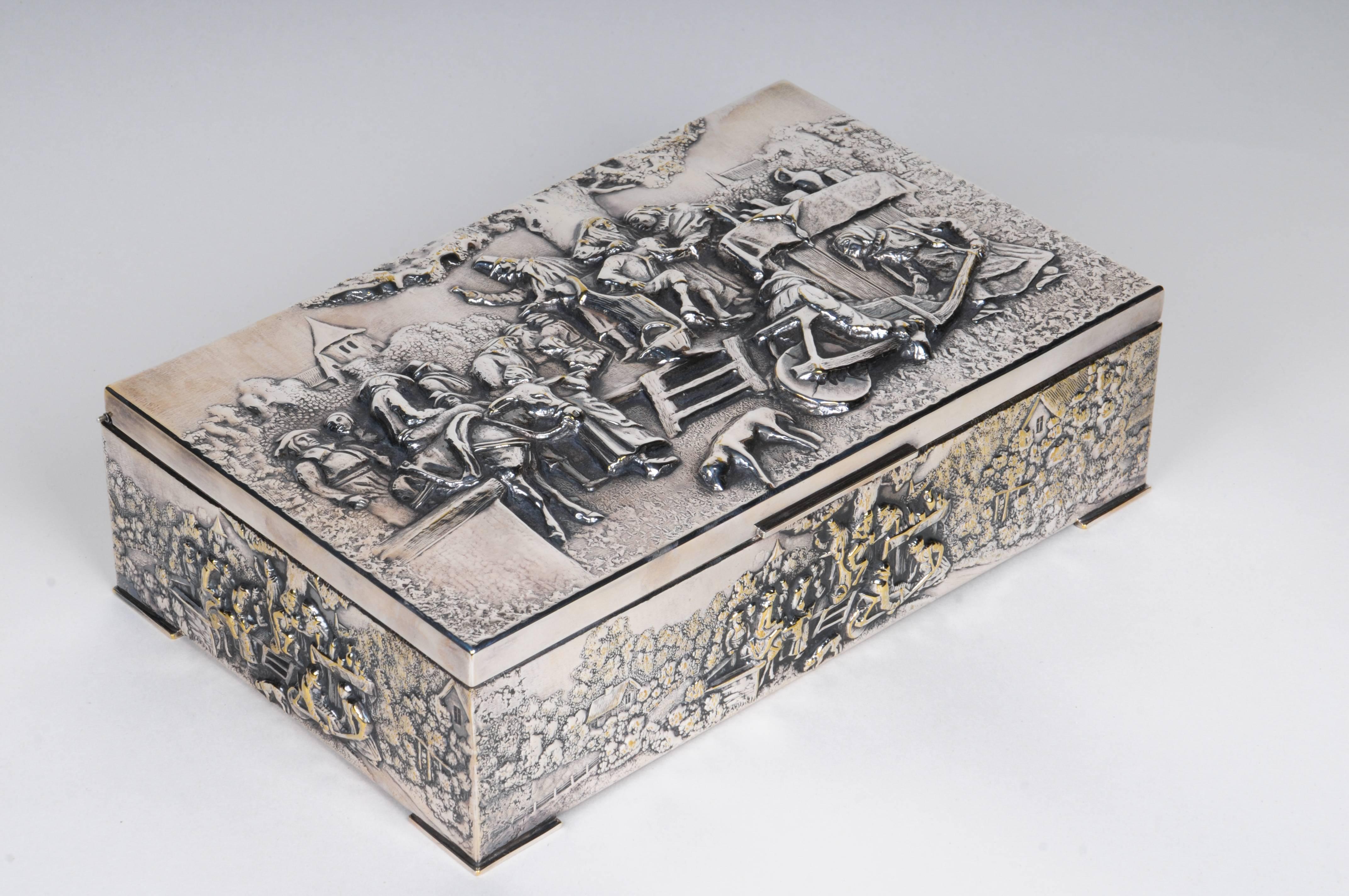 Continental Silverplate covered rectangular box
Cedar Interior. Hinged cover. High relief repousse village scene. Dutch or German. 
19th  - Early 20th C.
Size: 3"D x 6"W x 9.5"H