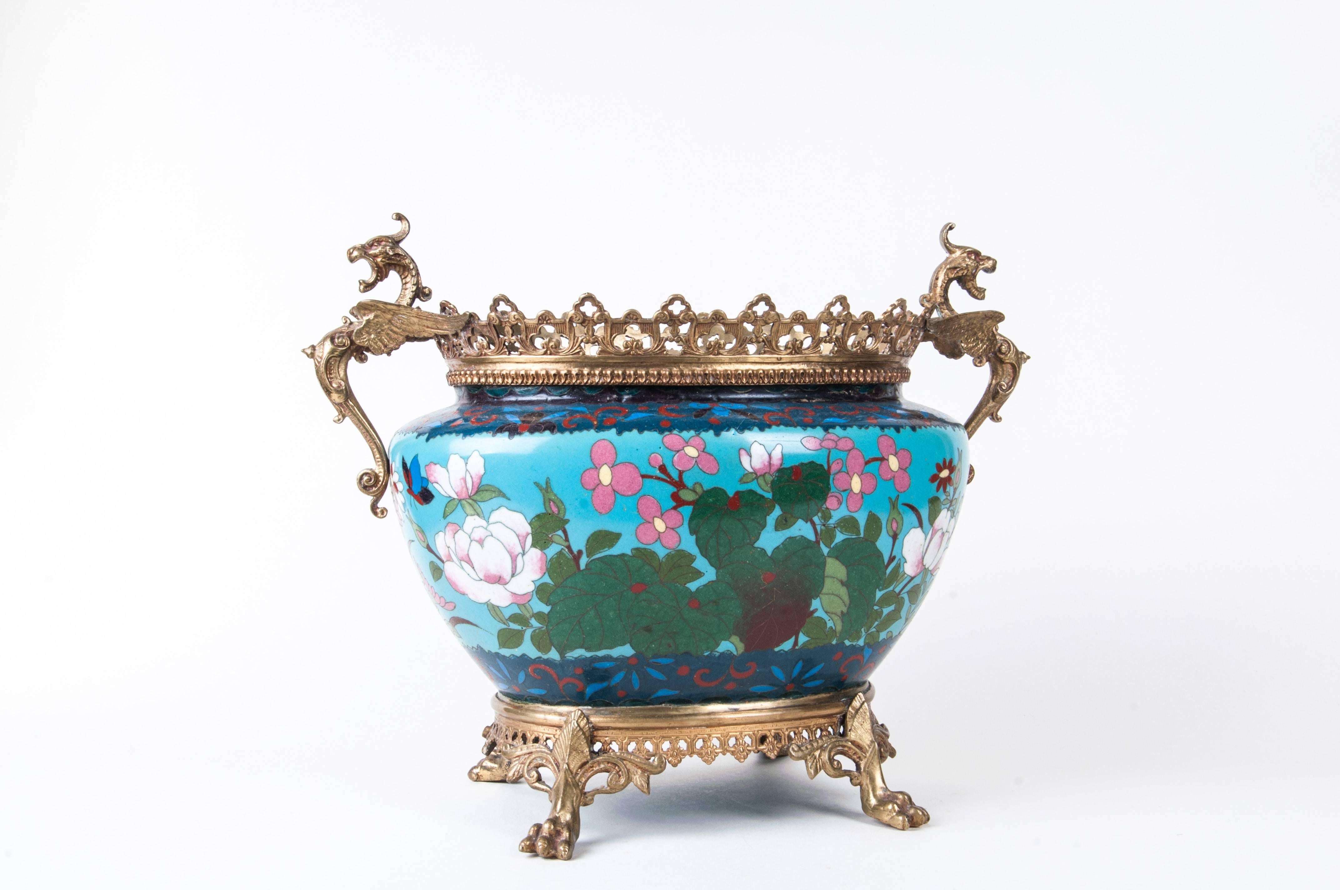 A French Japonisme ormolu-mounted Japanese cloisonné cachepot
The cloisonne body having bird, flower and butterfly motif with ormolu rims, griffin handles, and claw feet
Size: 10" H x 12" W x 7.5" D.