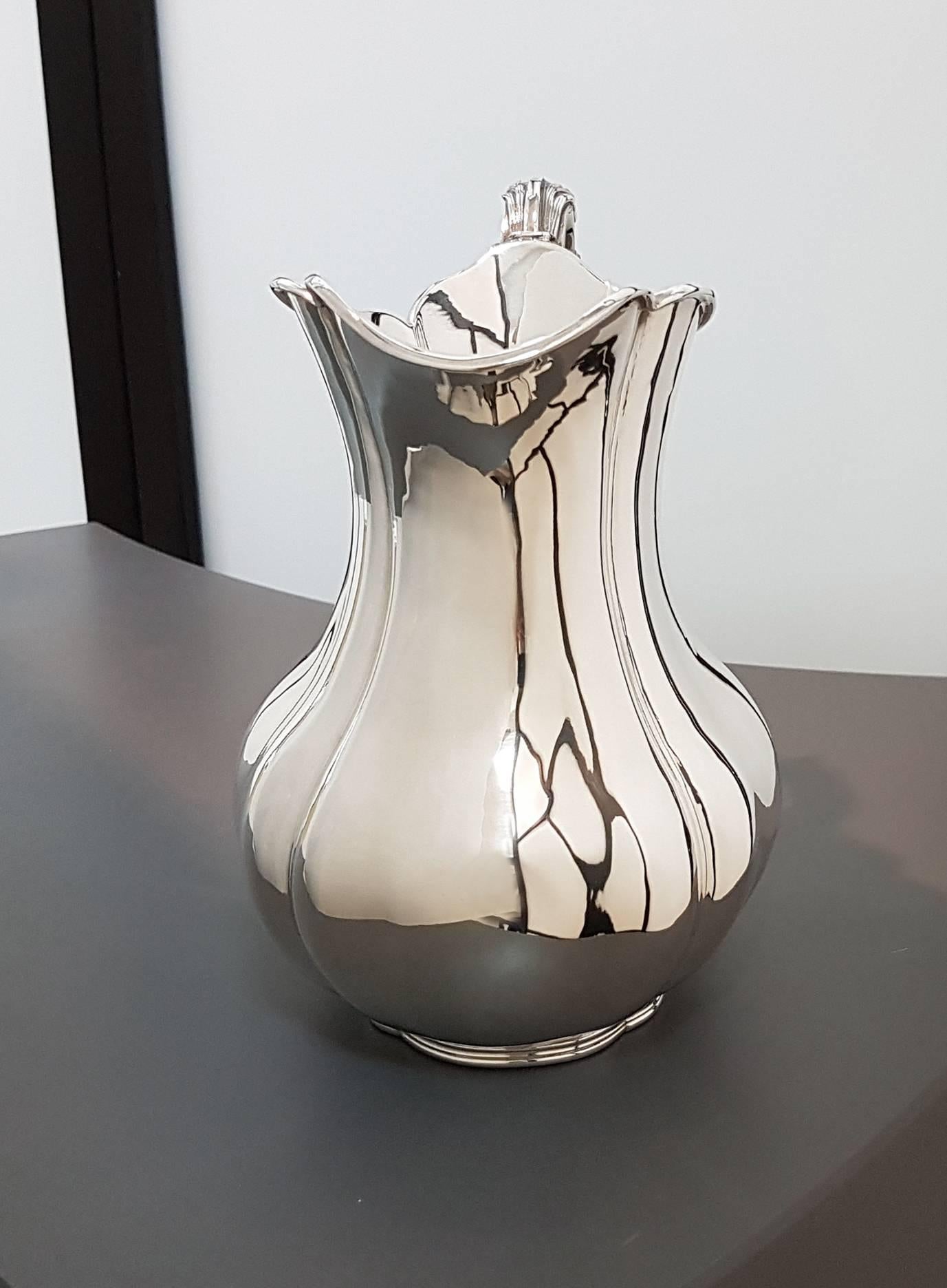 Sterling silver Italian Baroque style jug.
The jug body is smooth oval with four grooves typical of Baroque style.
The handle was made in melting and embellished with volute, also typical of the Baroque style.
780 grams

 