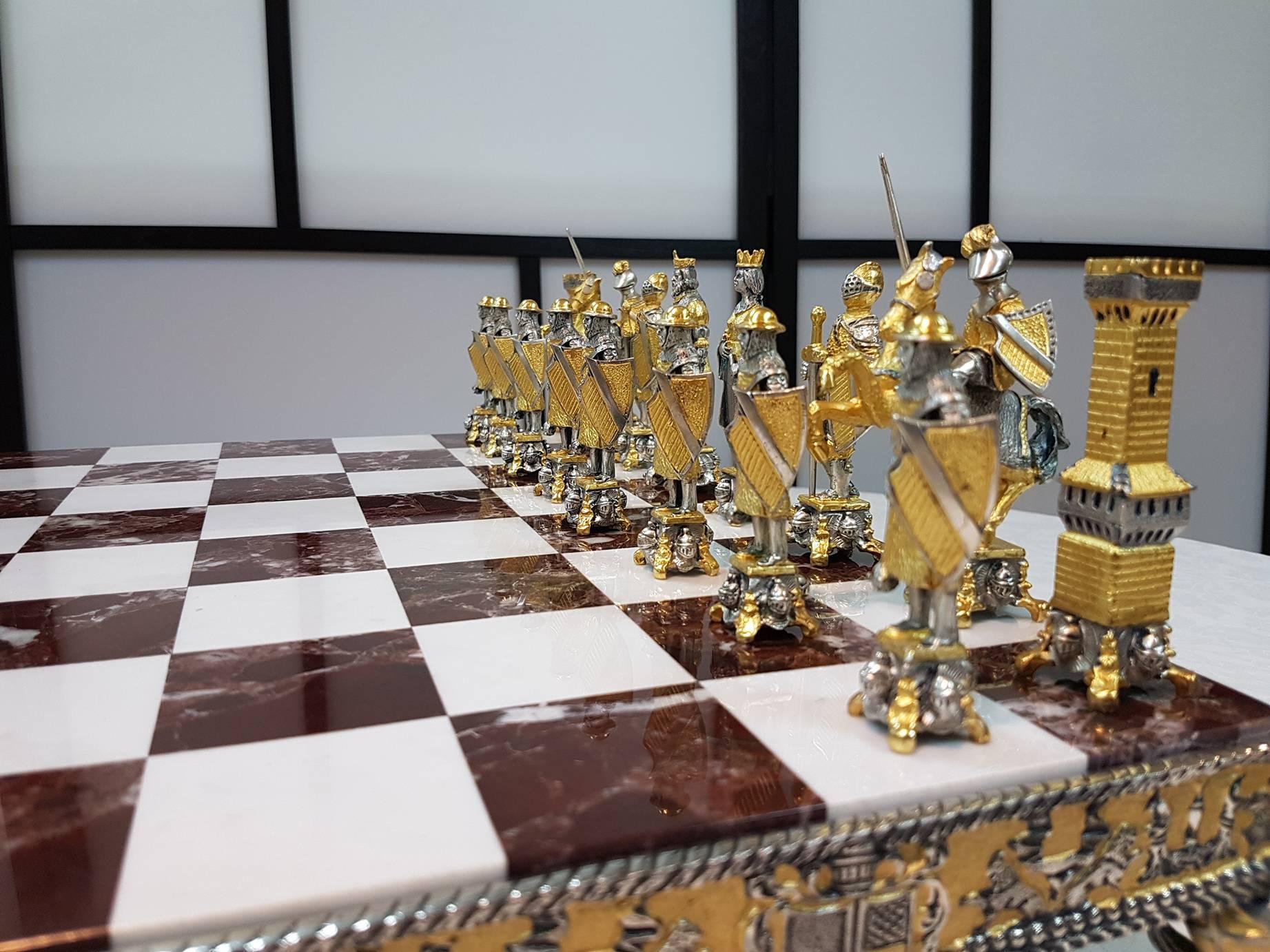 Sterling silver bi-color chessboard and chess game in medieval style.
The chessboard is in molten silver with red and white bi-color marble on four horses
Total 8,000 grams.