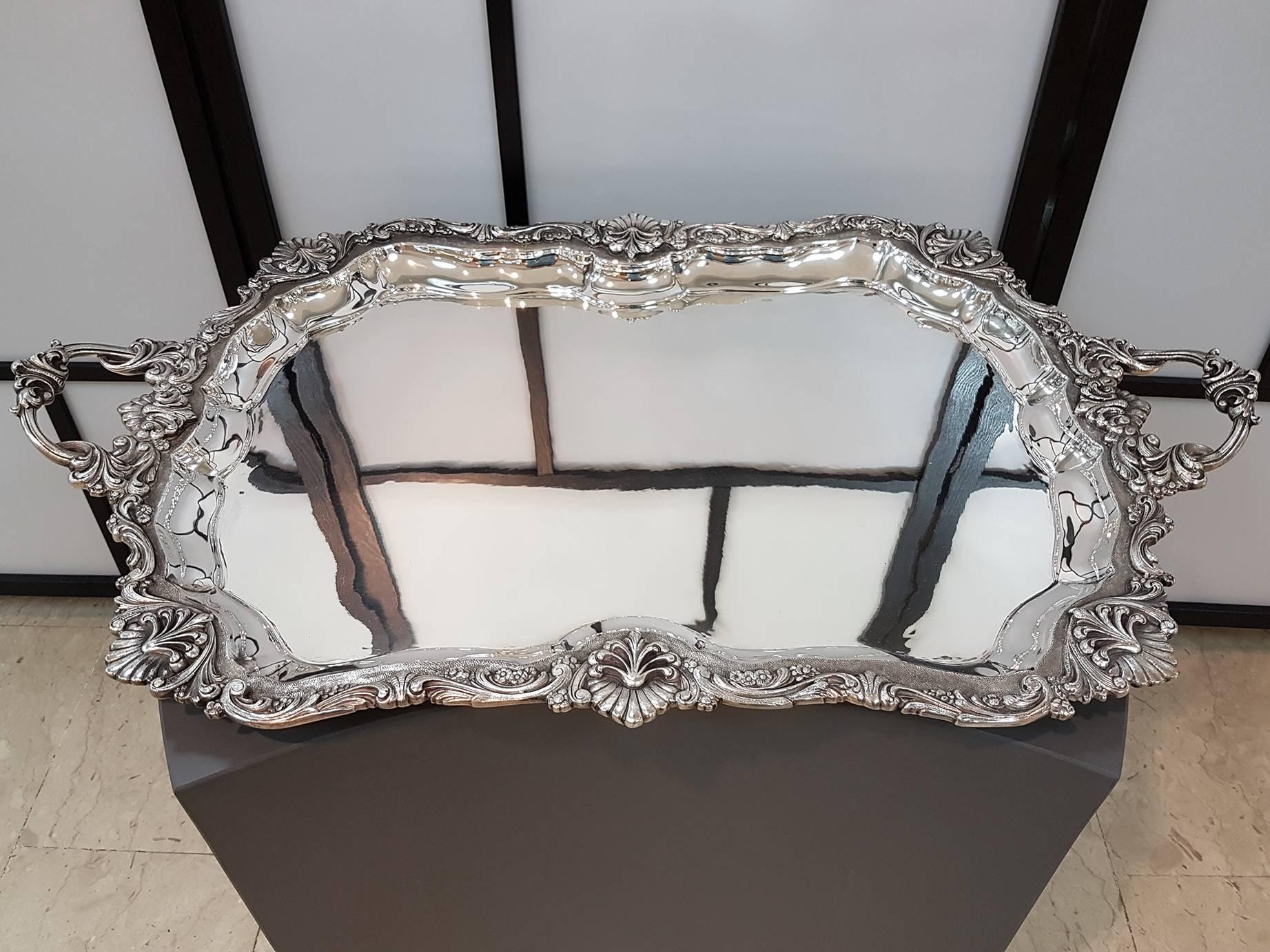 Big Barocco style silver tray with handles and 
the Stand is in a modern, square sectional style
The tray is solid silver 925   70(82 at the handles) x 50 cm. 6,700 grams
Stand is in solid silver 800   45x38 h.62 cm.  3,635 grams
  .