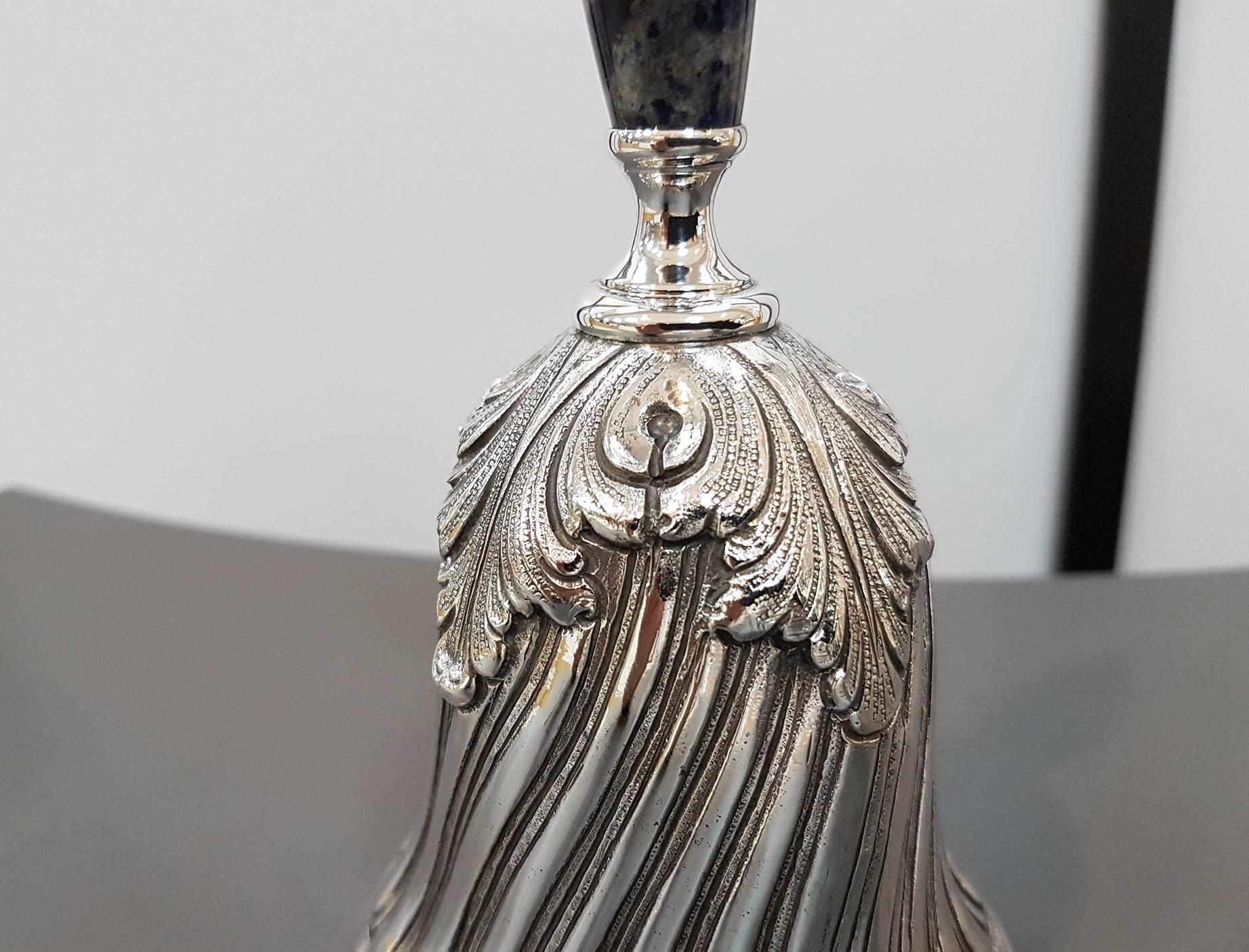 Sterling silver desk bell.
The torchon body is chiselled completely by hand and embellished with acanthus leaves.
The handle is in lapis lazuli with silver finishing
445 grams.
 