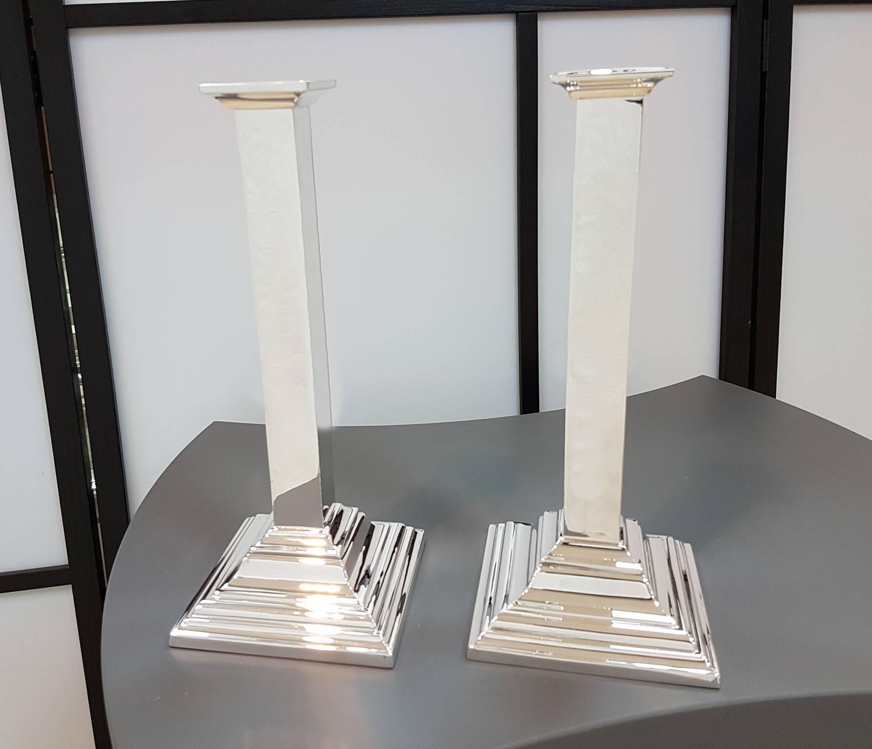 Pair of candlesticks in sterling silver completely handmade in a modern style. The base is square with steps while the stem, also square, is completely smooth with the upper part that widens slightly to accommodate the candle holder.
Minimalist