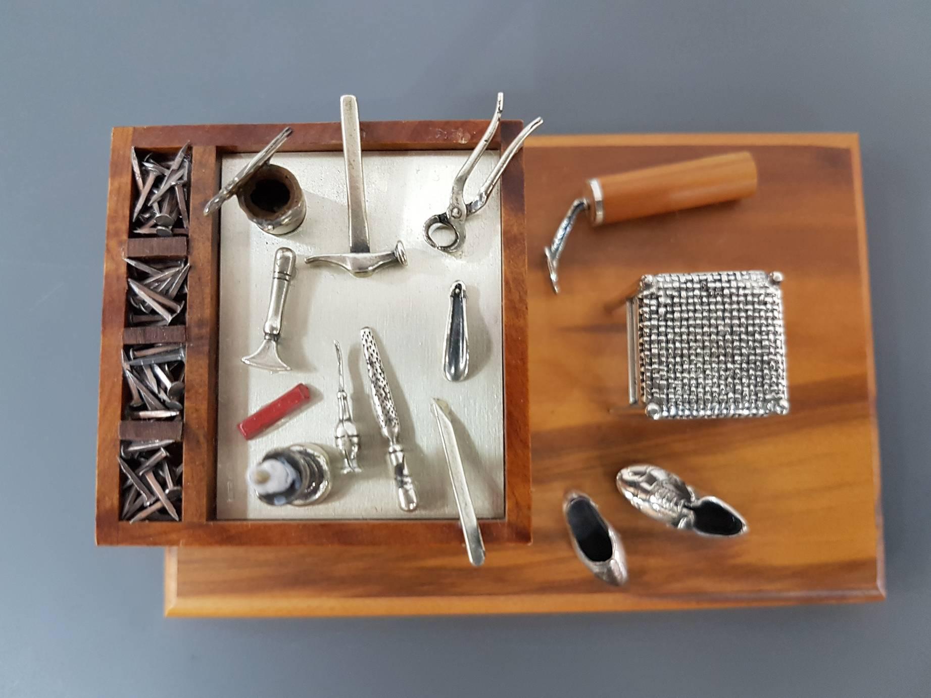 Wooden miniature with sterling silver details depicting the workshop of the cobbler.
All the details are reproduced in sterling silver with excellent finishing.

 