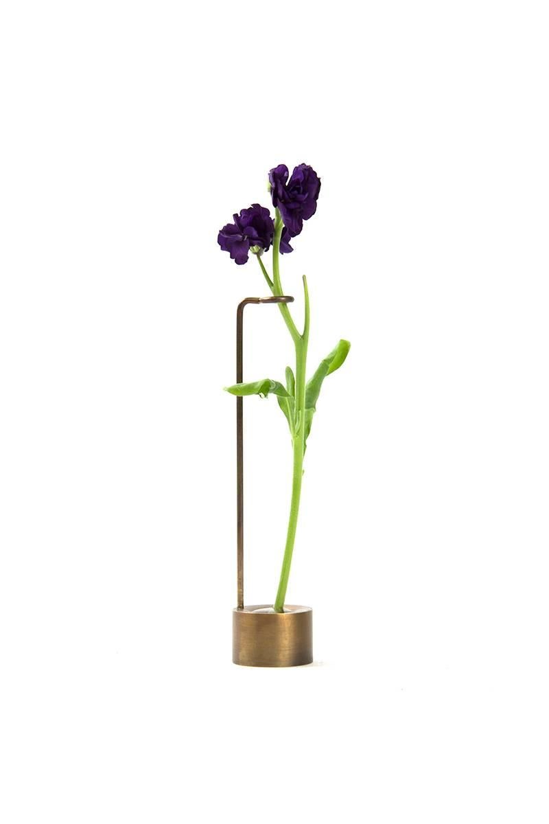 Each of these delicately, handcrafted bud vases is perfect as an individual home accessory or whimsical series. Made of brass and hand tarnished, each bud vase has its own unique formal language made from the base and stem support. In addition to