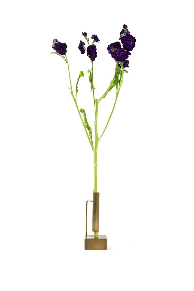 Each of these delicately, handcrafted bud vases is perfect as an individual home accessory or whimsical series. Made of brass and hand tarnished, each bud vase has its own unique formal language made from the base and stem support. In addition to