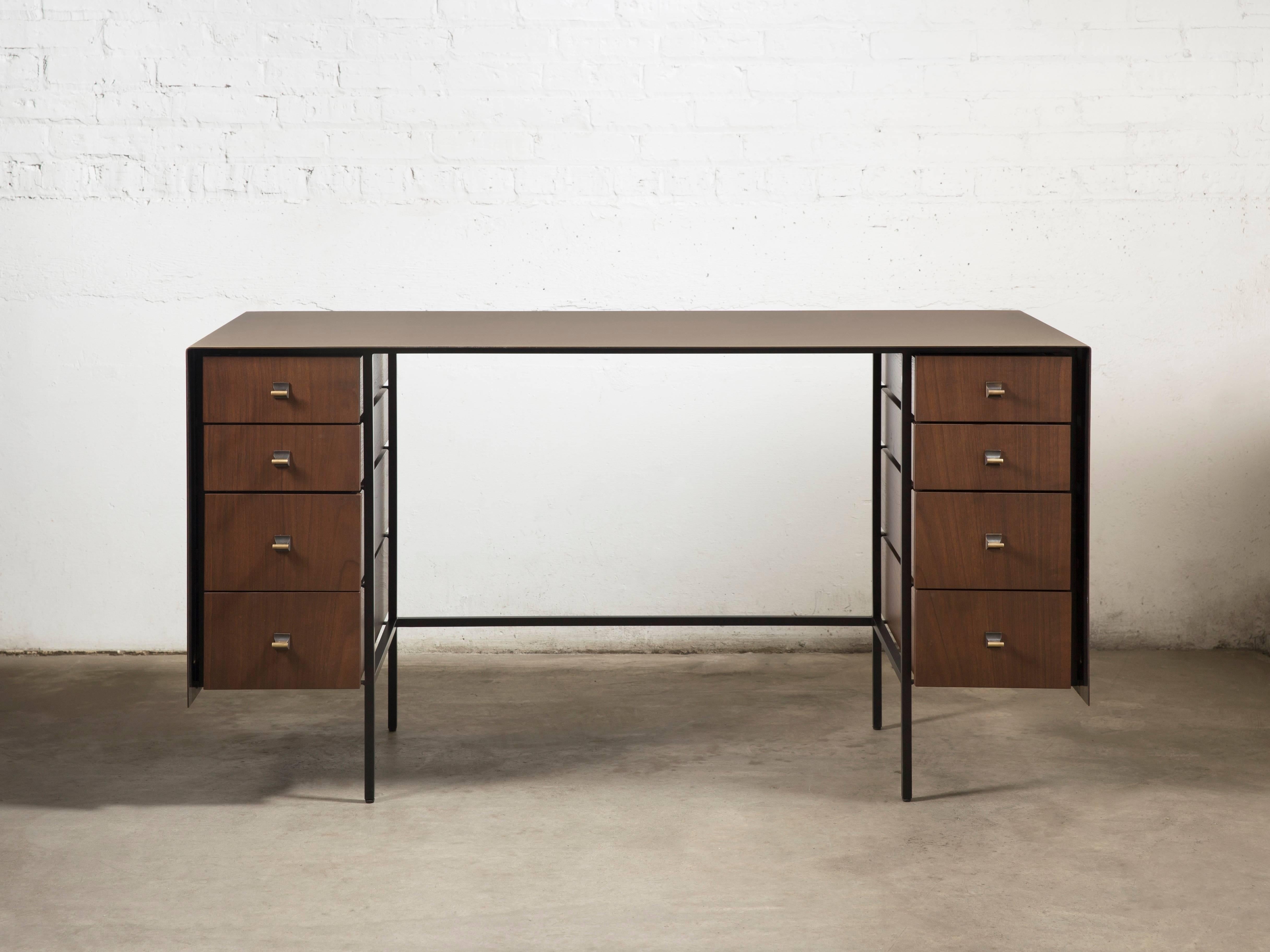A single brass sheet is bent creating the surface and sides, aptly giving the desk its name. The finish is darkened by hand through a proprietary solution and the drawers are made from solid walnut and veneered fronts. Perfect as a writing desk in