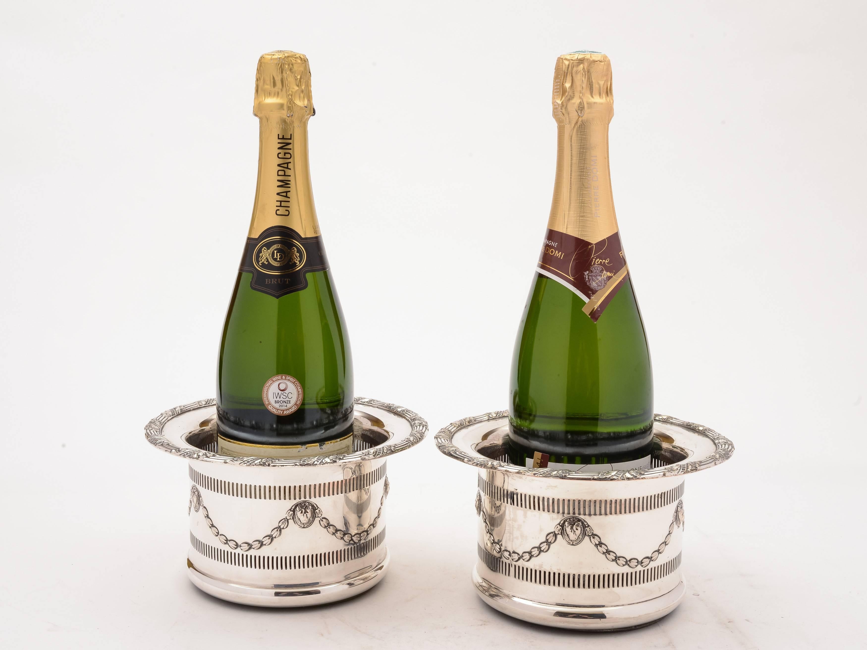A fabulous pair of English Edwardian silver plated champagne/wine coasters with embossed swag decoration and pierced decoration to body. Both have turned hardwood bases and central buttons, circa 1905.

Measurements:
Height: 4