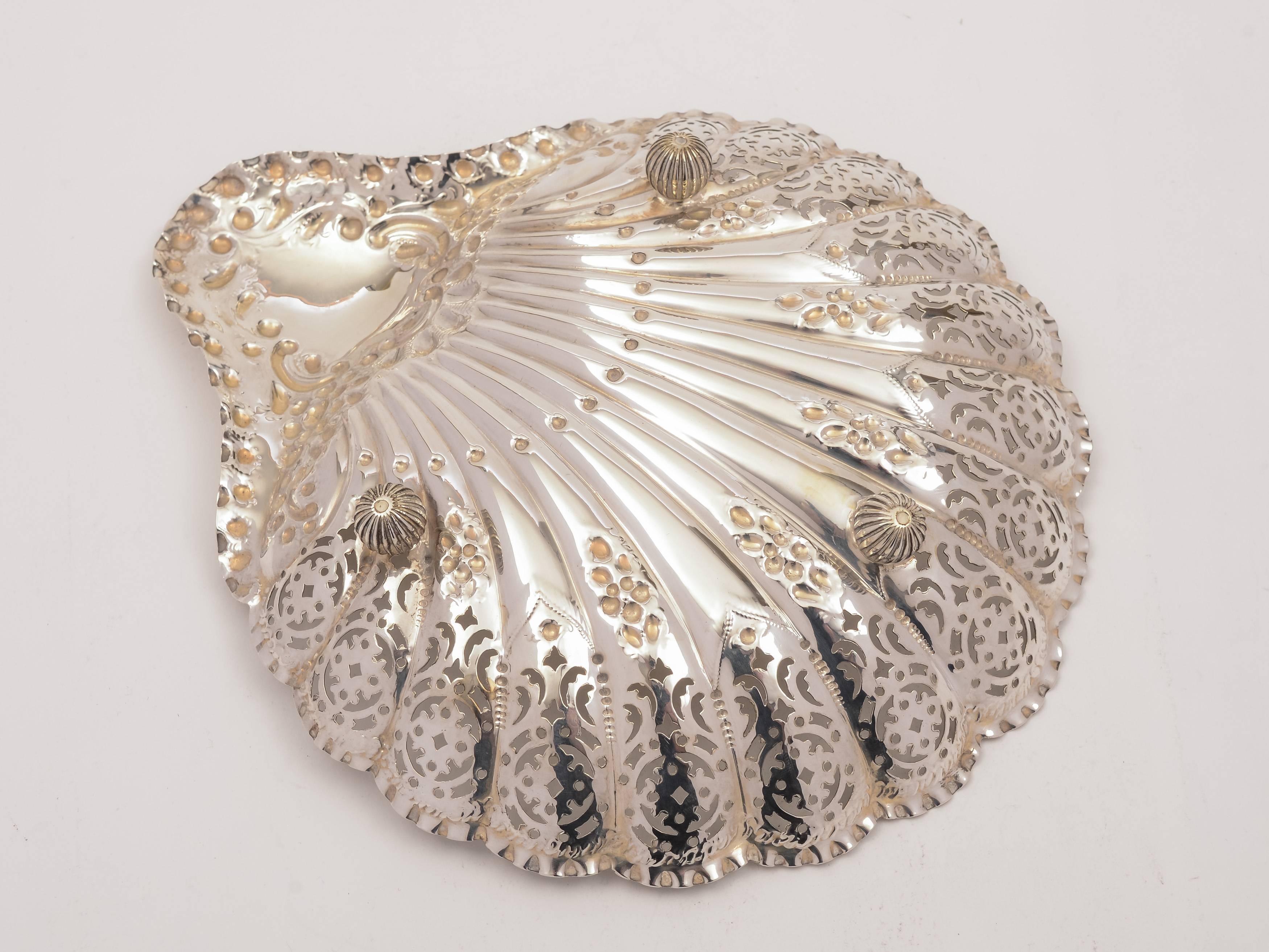 A pretty, good sized, English Victorian silver shell-shaped serving dish with beautiful pierced and embossed decoration and sits on ball feet. Hallmarked Sheffield 1896 and marked 'H A' for maker Atkin Brothers, Harry Atkins. 

Silver weight: 245g