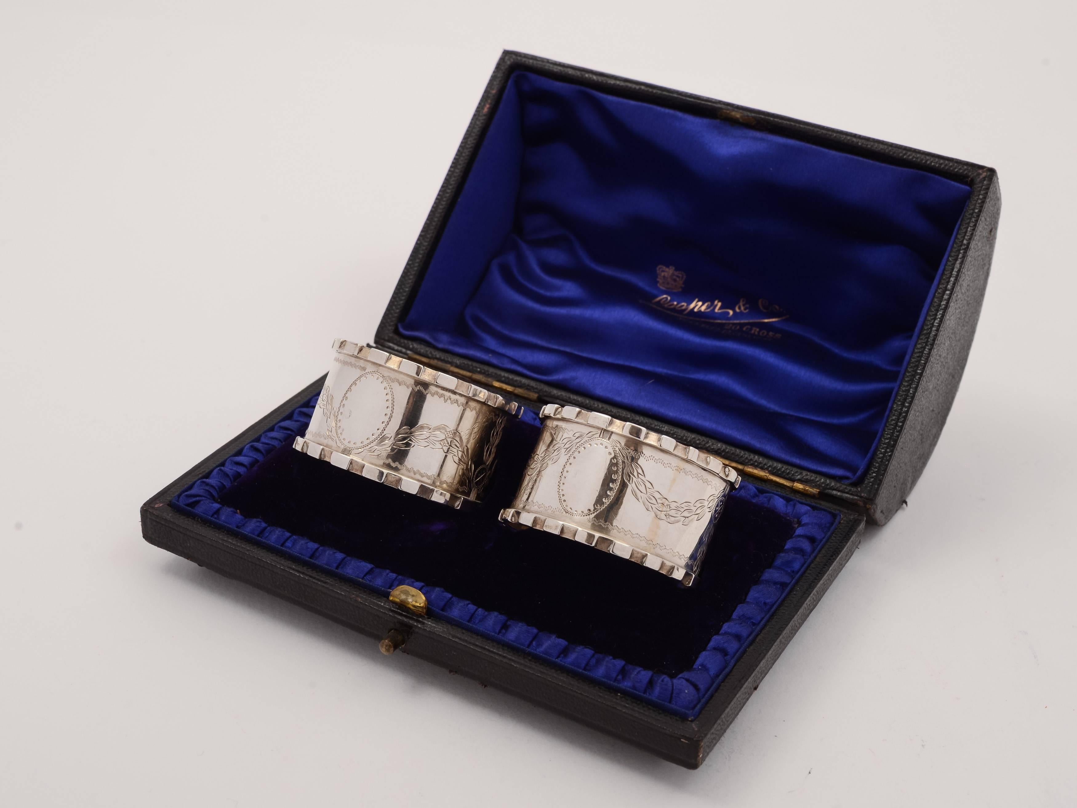 A nice pair of English George V silver napkin rings with engraved swag decoration with vacant cartouches. Presented in blue silk and velvet lined box and hallmarked Birmingham 1913. Marked 'R P' for maker Robert Pringle & Sons. 

Silver weight: