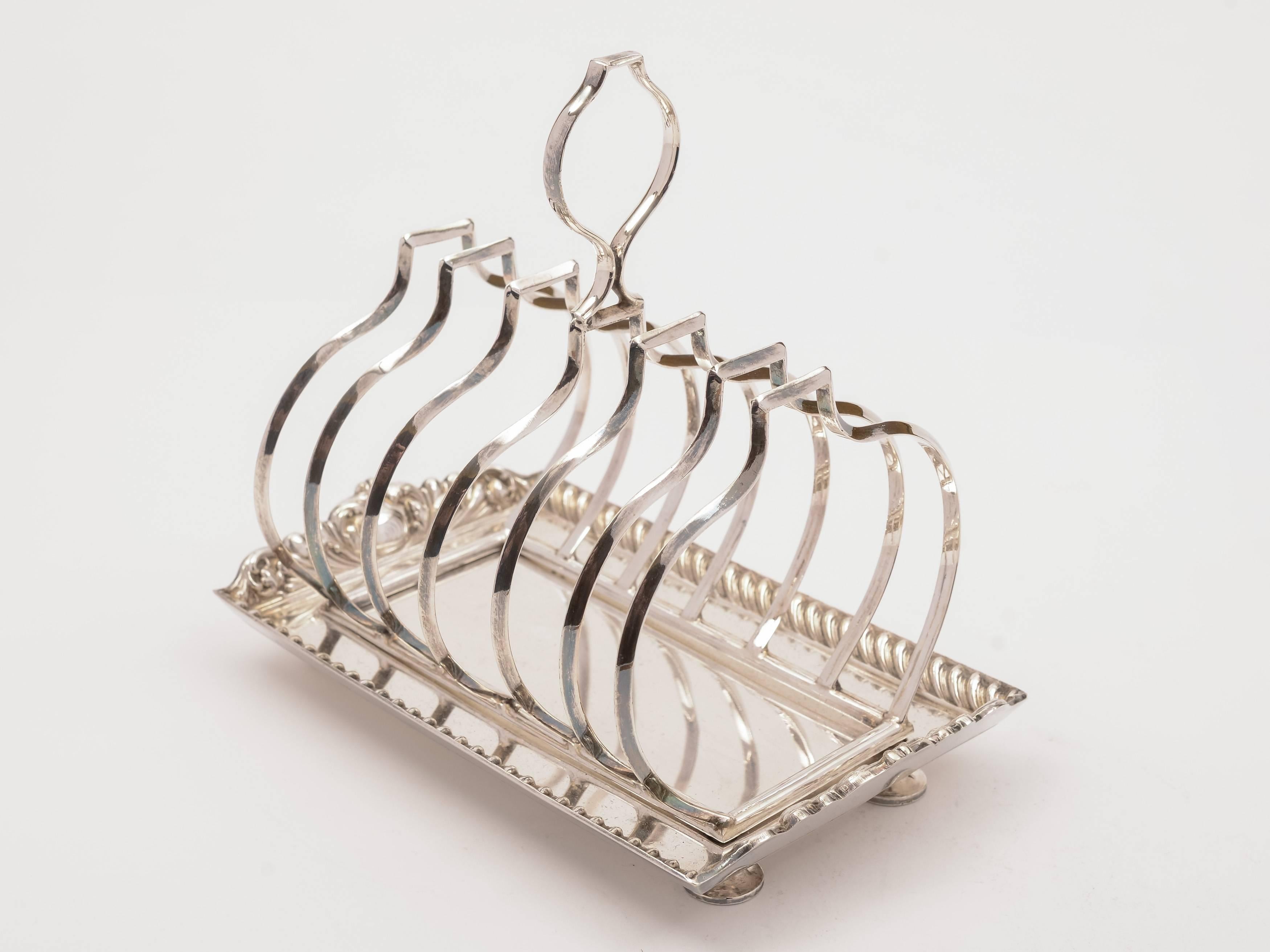 A lovely English Edwardian silver plated toast rack with embossed decoration to edge of base and sits on bun feet, circa 1905 and marked 'R & B' for maker Samuel Roberts and Charles Belk, Furnival Works, Sheffield. 

Weight: 400g.
  