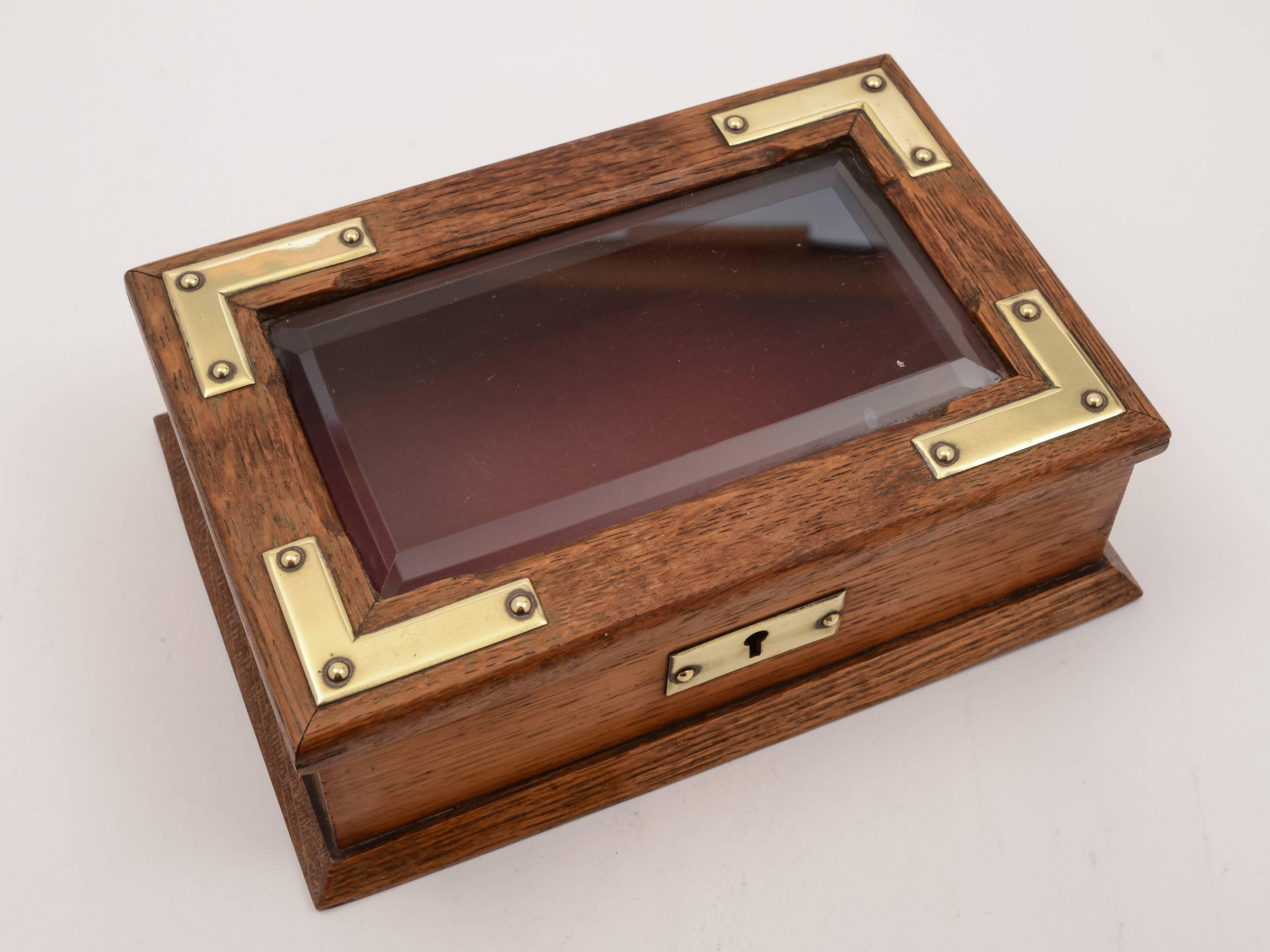 A good English Edwardian oak jewelry box with brass mounts, bevelled glass top, functioning lock and key, circa 1905.

Total weight: 1088g.
         