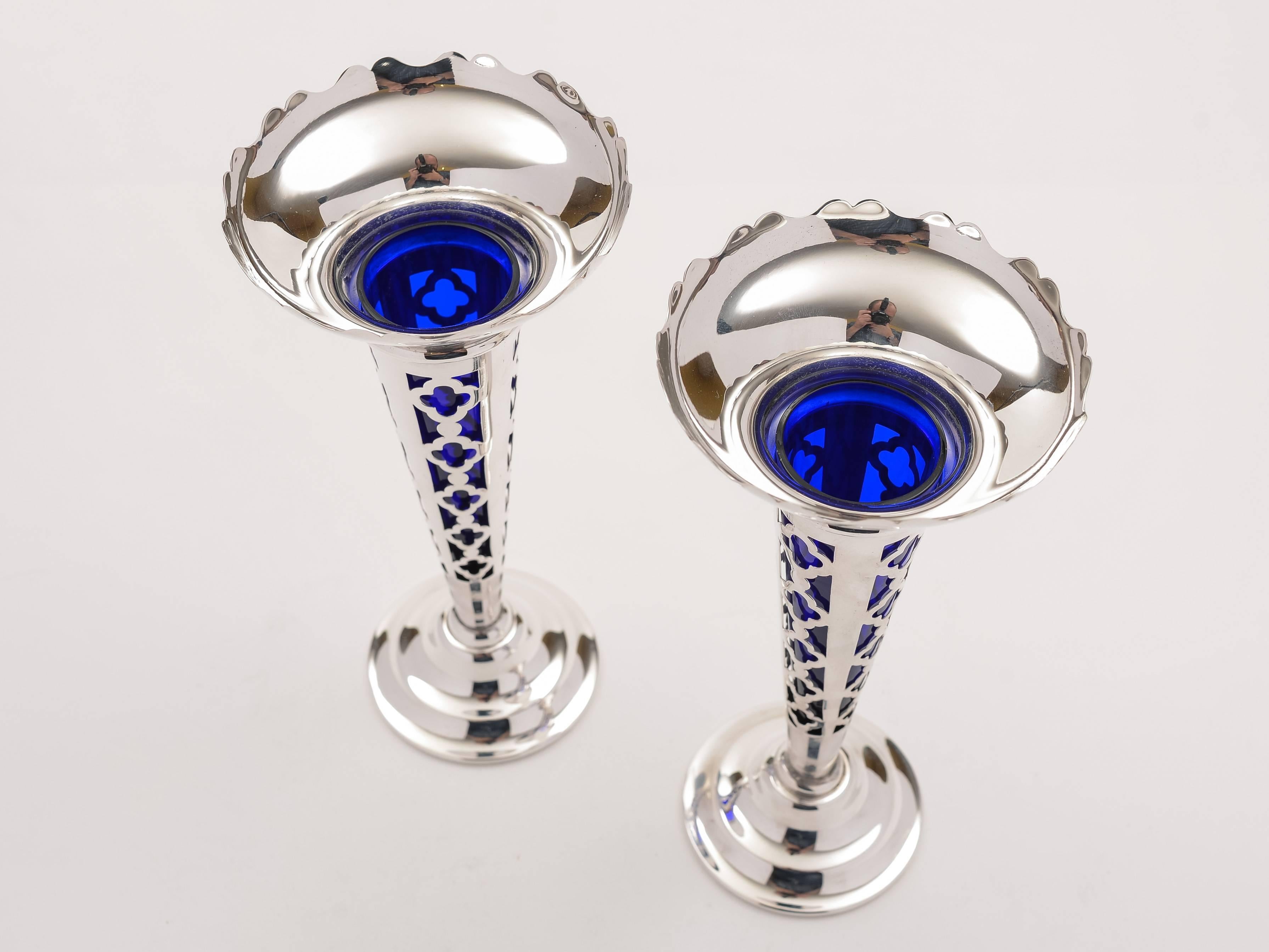 A lovely pair of English Art Deco silver plated vases with cobalt blue liners and card cut tops, with lattice pierced decoration to bodies, circa 1930.

Lovely pair of vases, would make a wonderful gift.

 