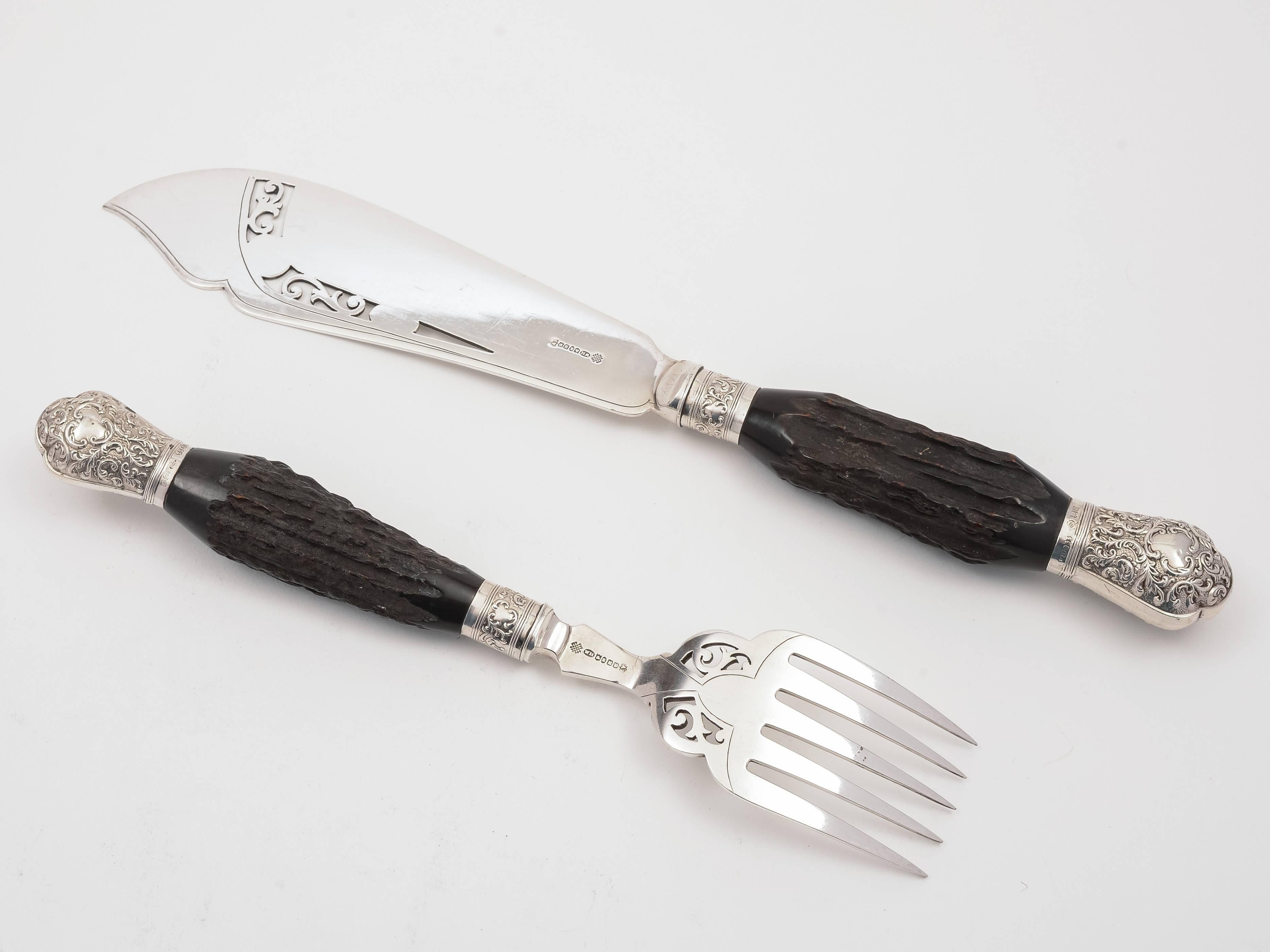 A good pair of English Edwardian antler and silver handled fish servers with silver plated pierced and engraved blade and fork. By the renowned maker Walker and Hall and with silver embossed antler handles which are hallmarked Sheffield