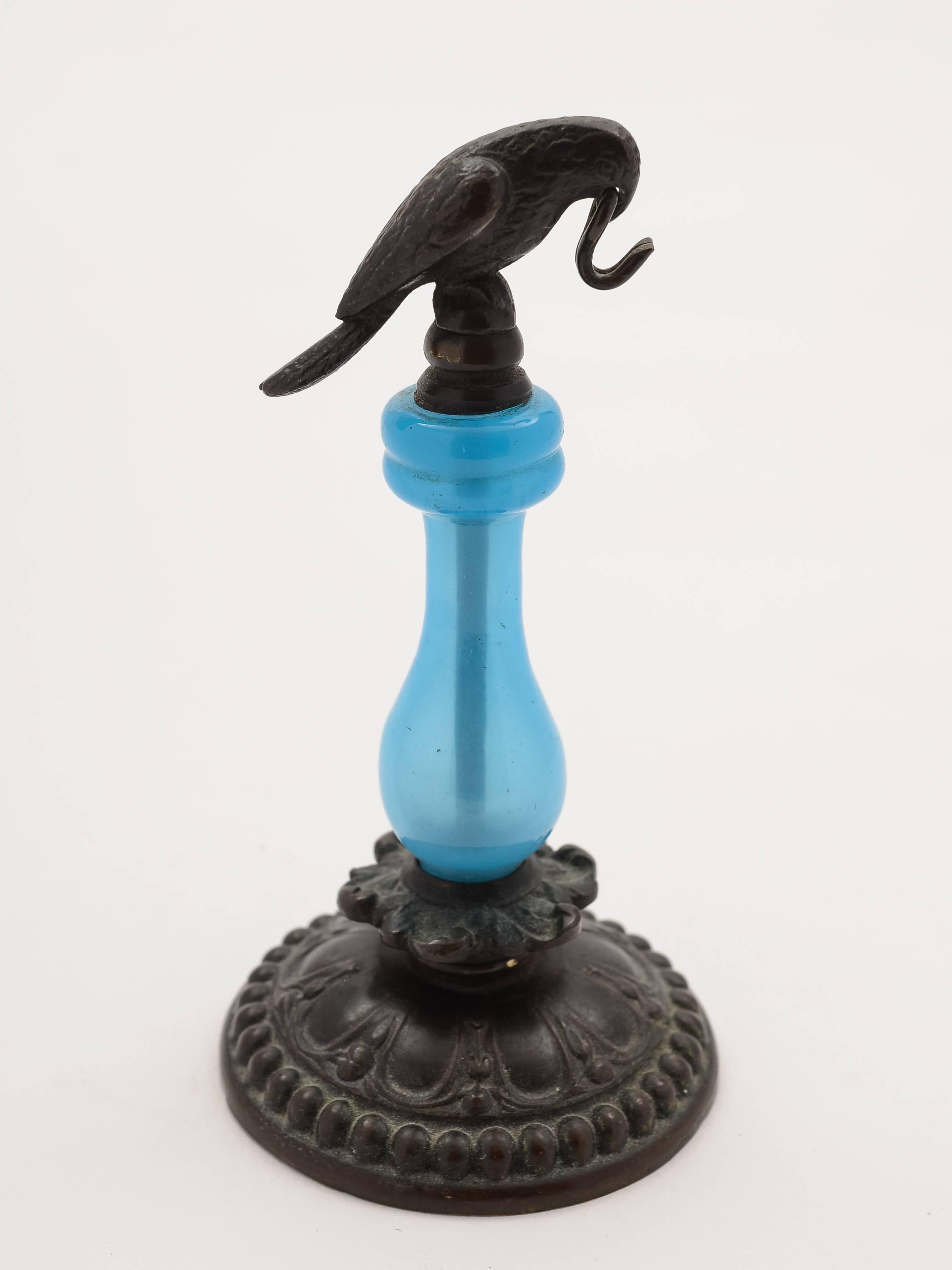 A nice novelty brass watch stand (probably French) with blue opaque glass column to centre with bird perched on top with hook for hanging watch from, circa 1880.

Total weight: 178g

These often would have been kept by the bedside to hang your