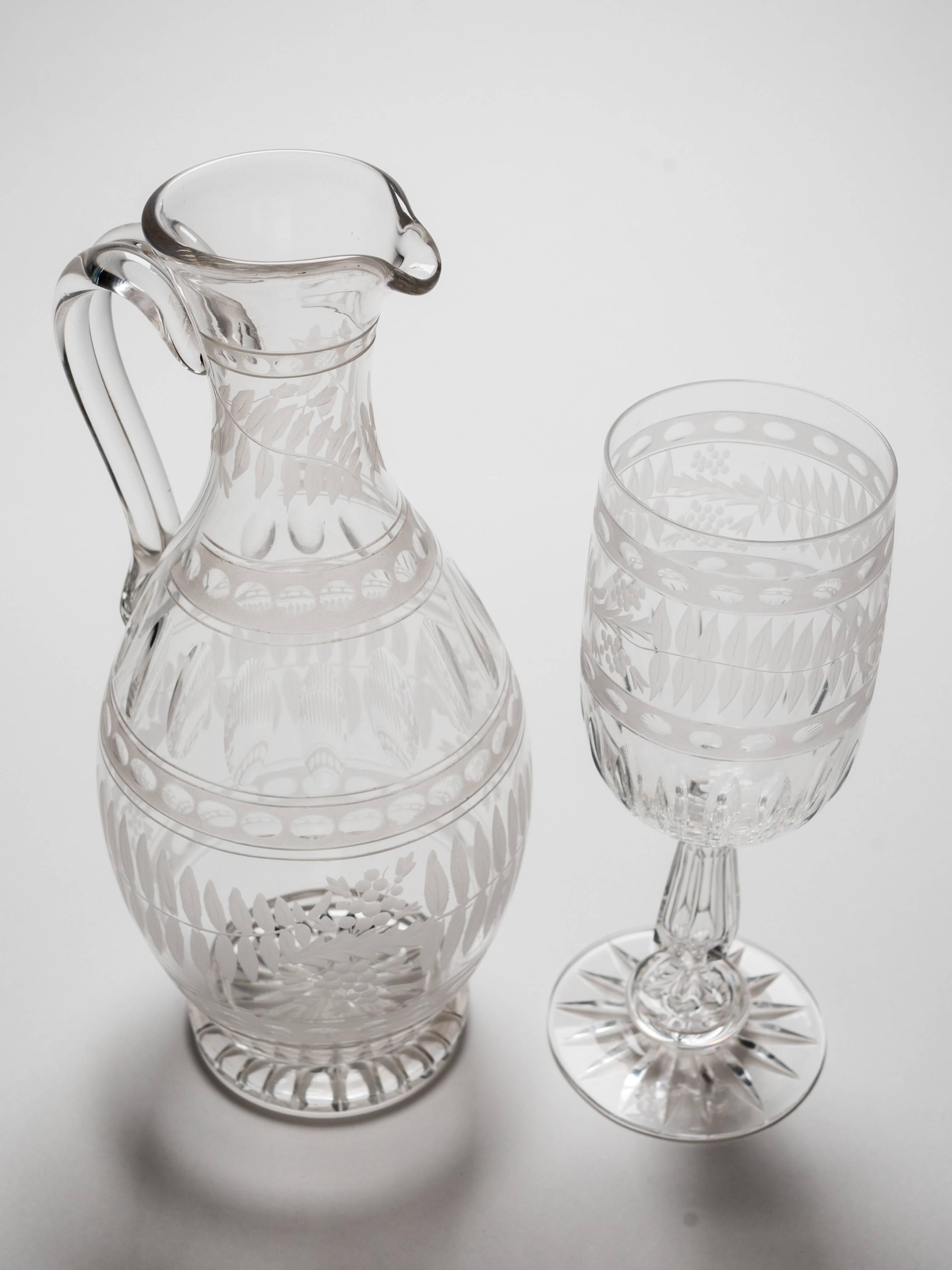 A beautiful English Victorian cut-glass claret jug and goblet, both with lovely etched decoration and star cut bases. The jug has a strap handle and the goblet has a hollow stem, circa 1890.

Measurements:
Claret jug height: 10 1/2