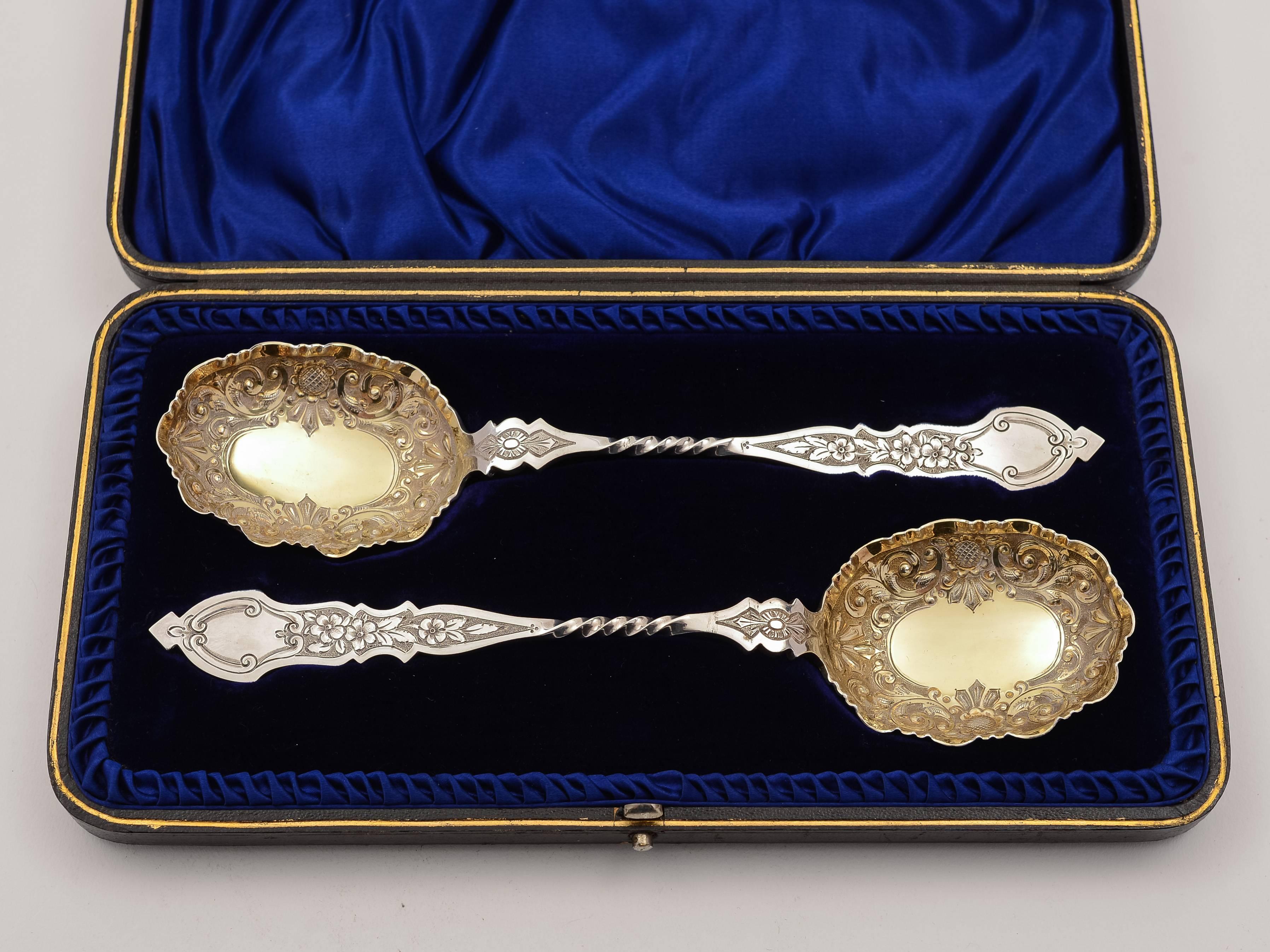 A stunning pair of English Victorian silver serving spoons with embossed and gilt bowls and engraved shaped handles. Presented in original box which has blue velvet and silk lining. Hallmarked Sheffield 1892 and marked 'TL' for Levesley Brothers -