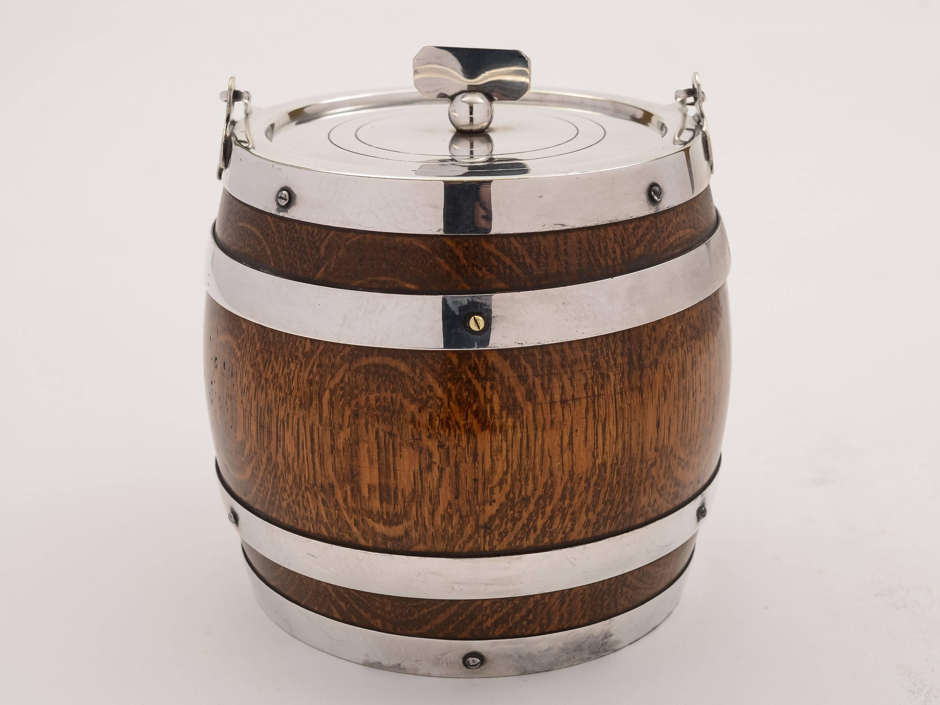 A good English Victorian oak and silver plated biscuit barrel/cookie jar with fold-down handle and vacant shield cartouche, circa 1890. marked 'D A' for maker Daniel Arter. 

Total weight: 1395g.

