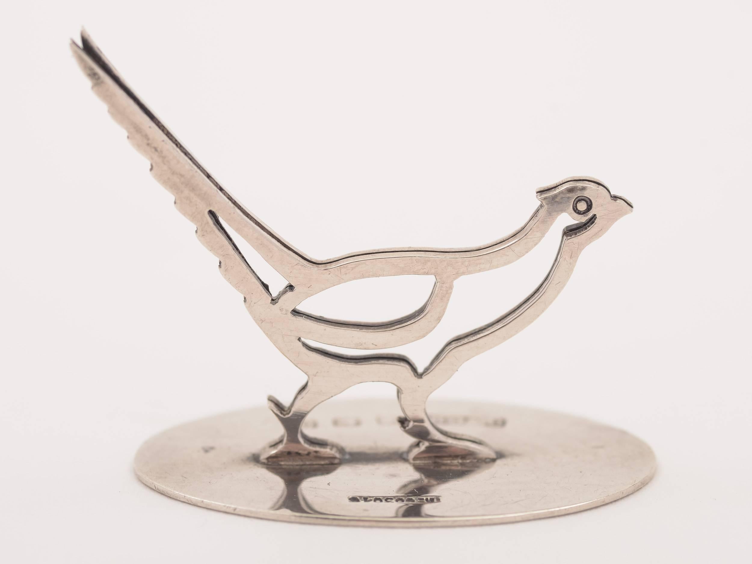 An unusual English silver menu holder modelled on a pheasant, hallmarked Birmingham 1913. Has manufacturers mark to base for A. Barrett & Sons, 63 & 64 Piccadilly, London.

 