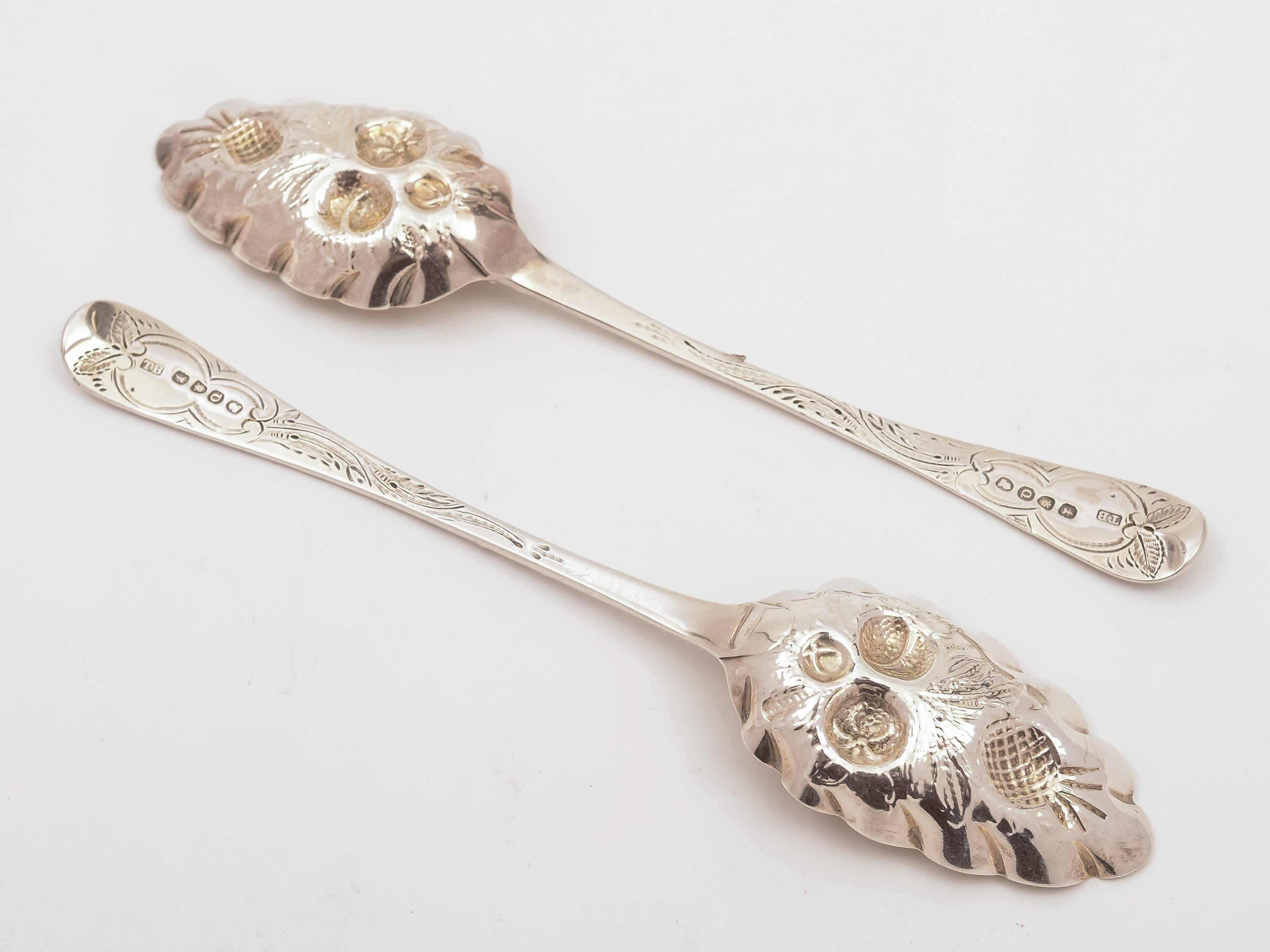 A lovely pair of English Georgian silver serving spoons with embossed fruit decoration and original gilding to bowls and engraved decoration to handles which have vacant cartouches to ends. Hallmarked London 1811 and marked 'T.B' for the maker