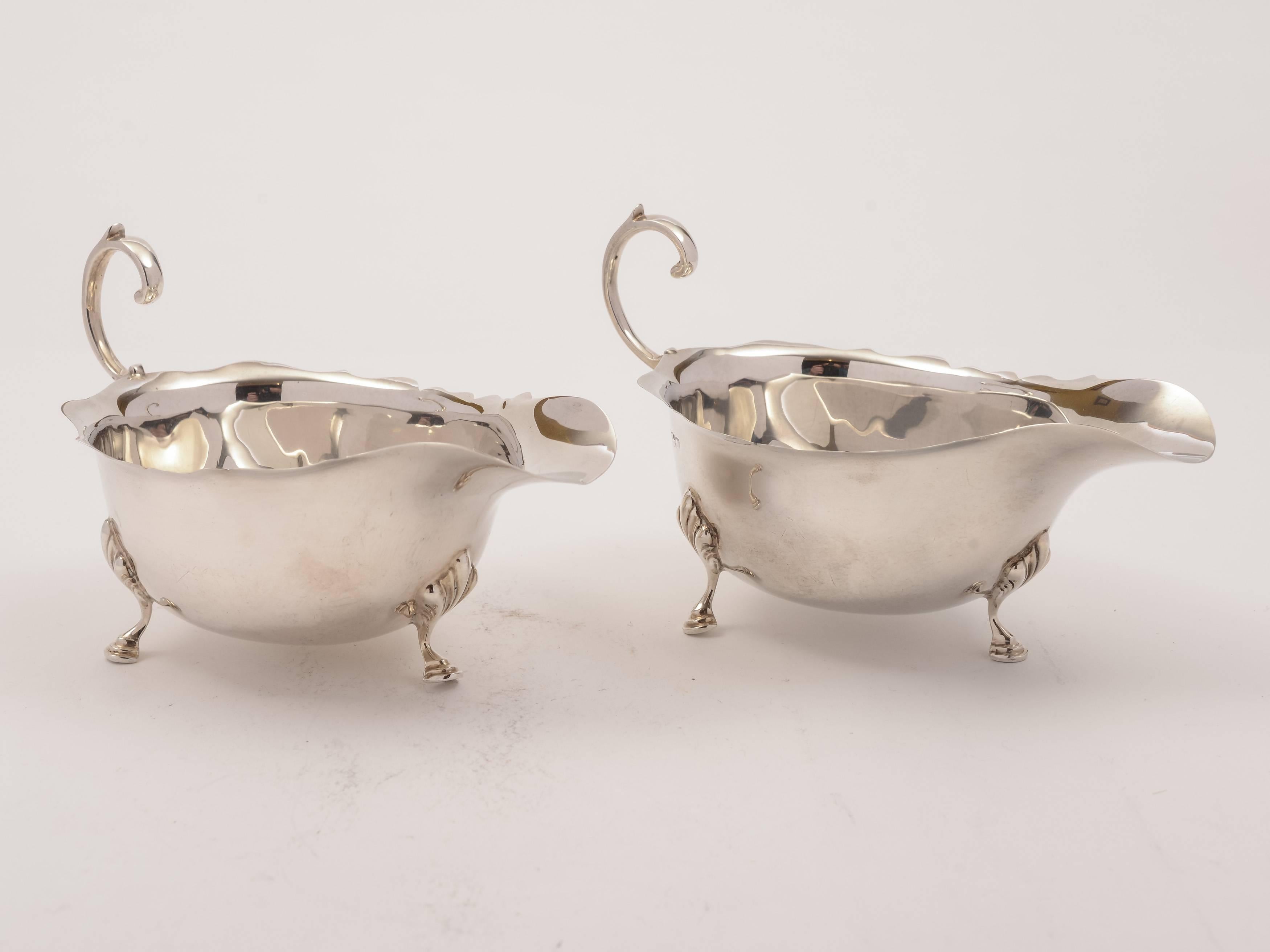 A lovely pair of English Art Deco period silver sauce boats which Stand on three feet, have card cut decoration to tops and scroll handles. Hallmarked Sheffield 1929 and marked 'B & S' for the maker Brook & Son. 

Measurements:
Height 3