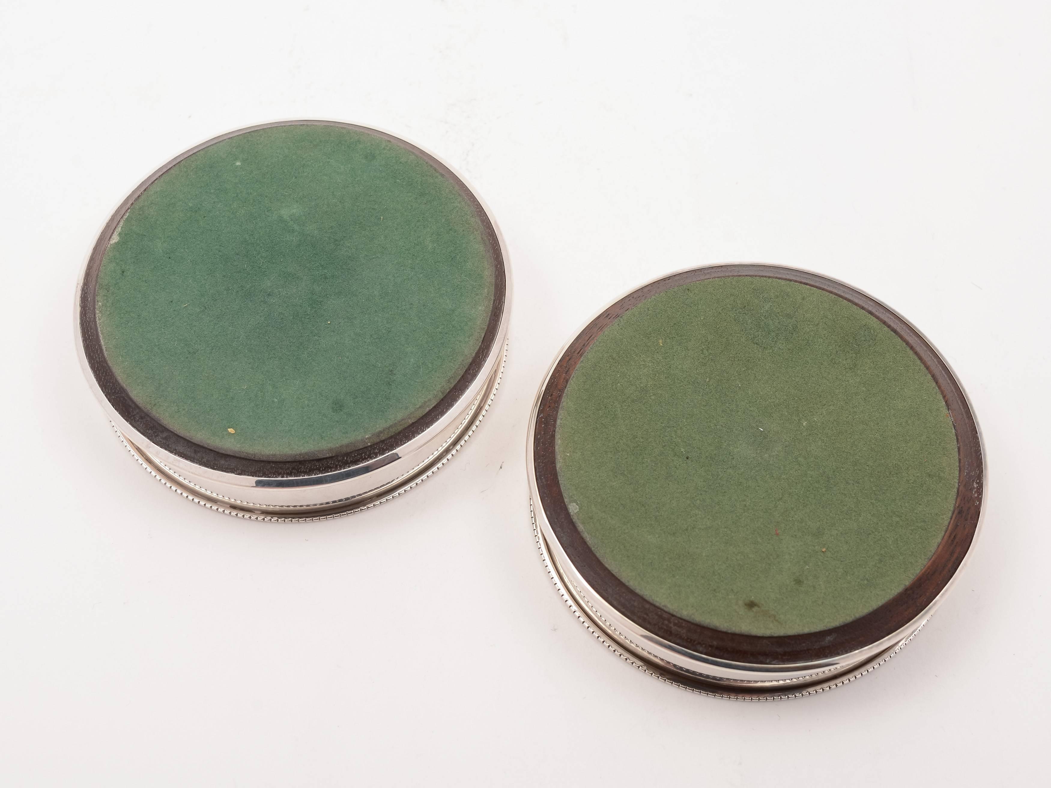 A lovely pair of English vintage silver wine coasters with turned hardwood bases and plain silver sides. Hallmarked Birmingham 1992 and marked 'P H V & Co' for maker P H Vogel & Co. 

Measurements:
Height 3/4