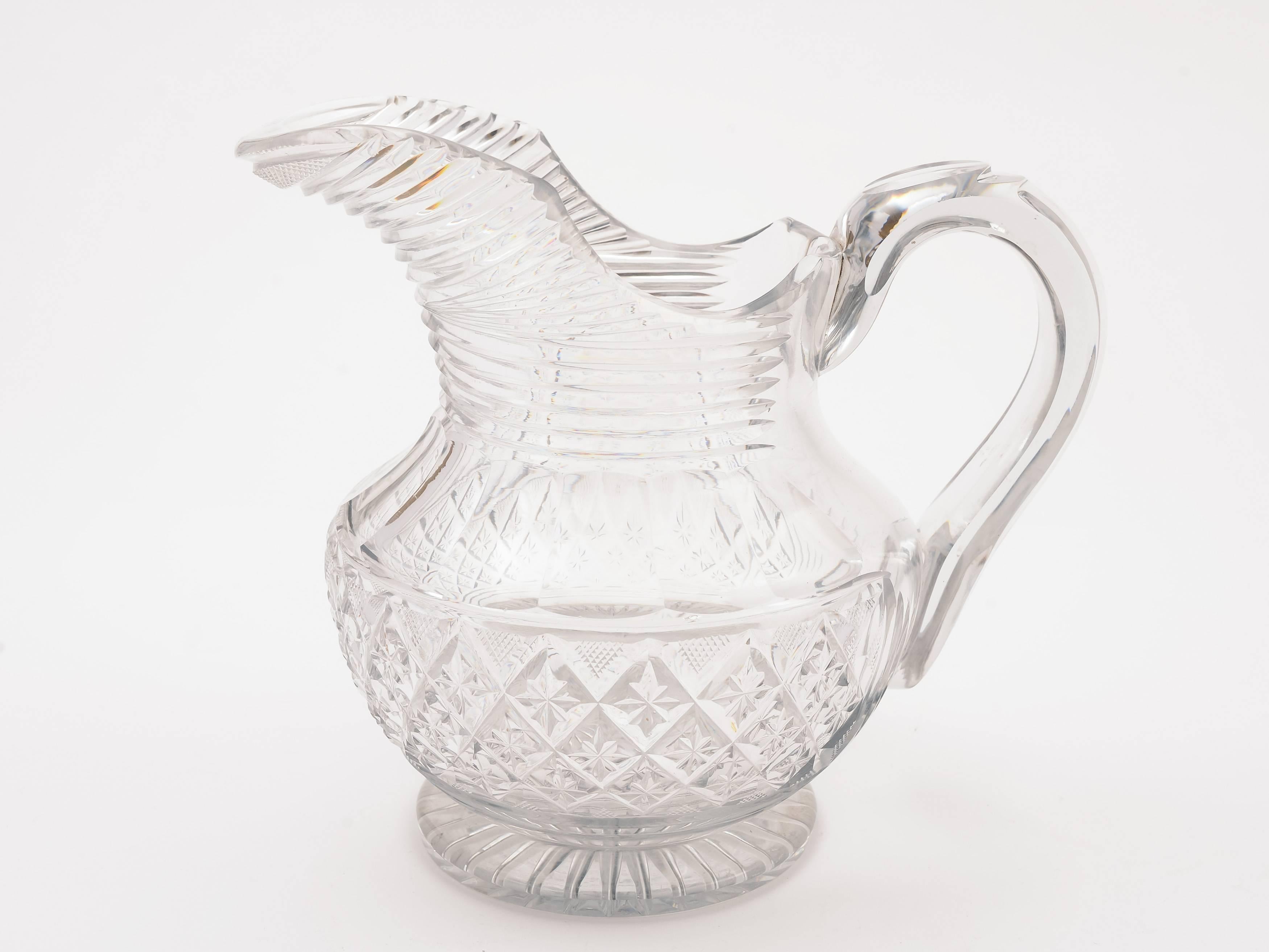 A nice English Georgian cut-glass water jug/pitcher with strap handle and star cut base, circa 1810.

Measurements:
Height: 7